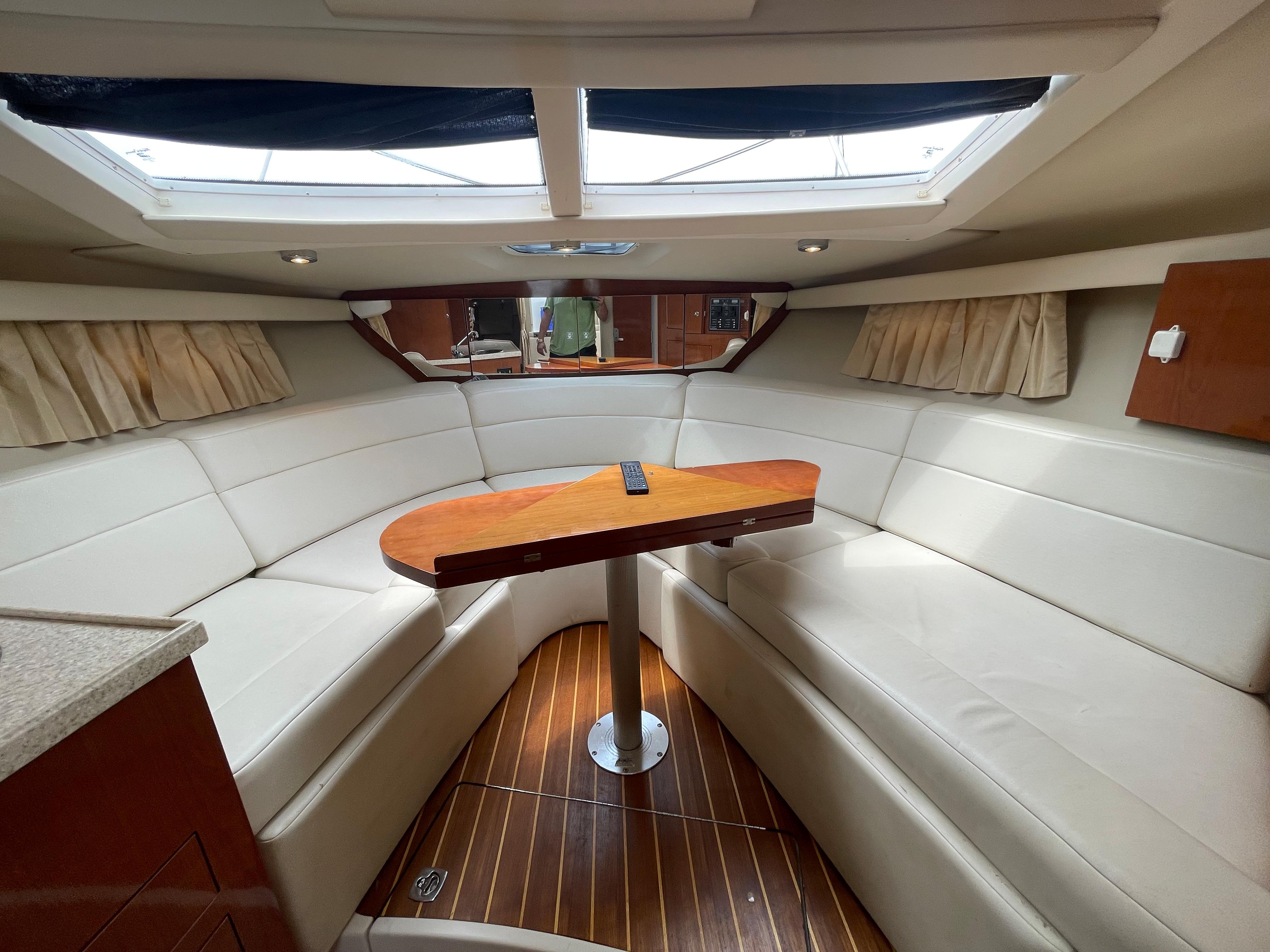 Interior of 2006 Regal 3060 Window Express boat with white seating and wooden table.