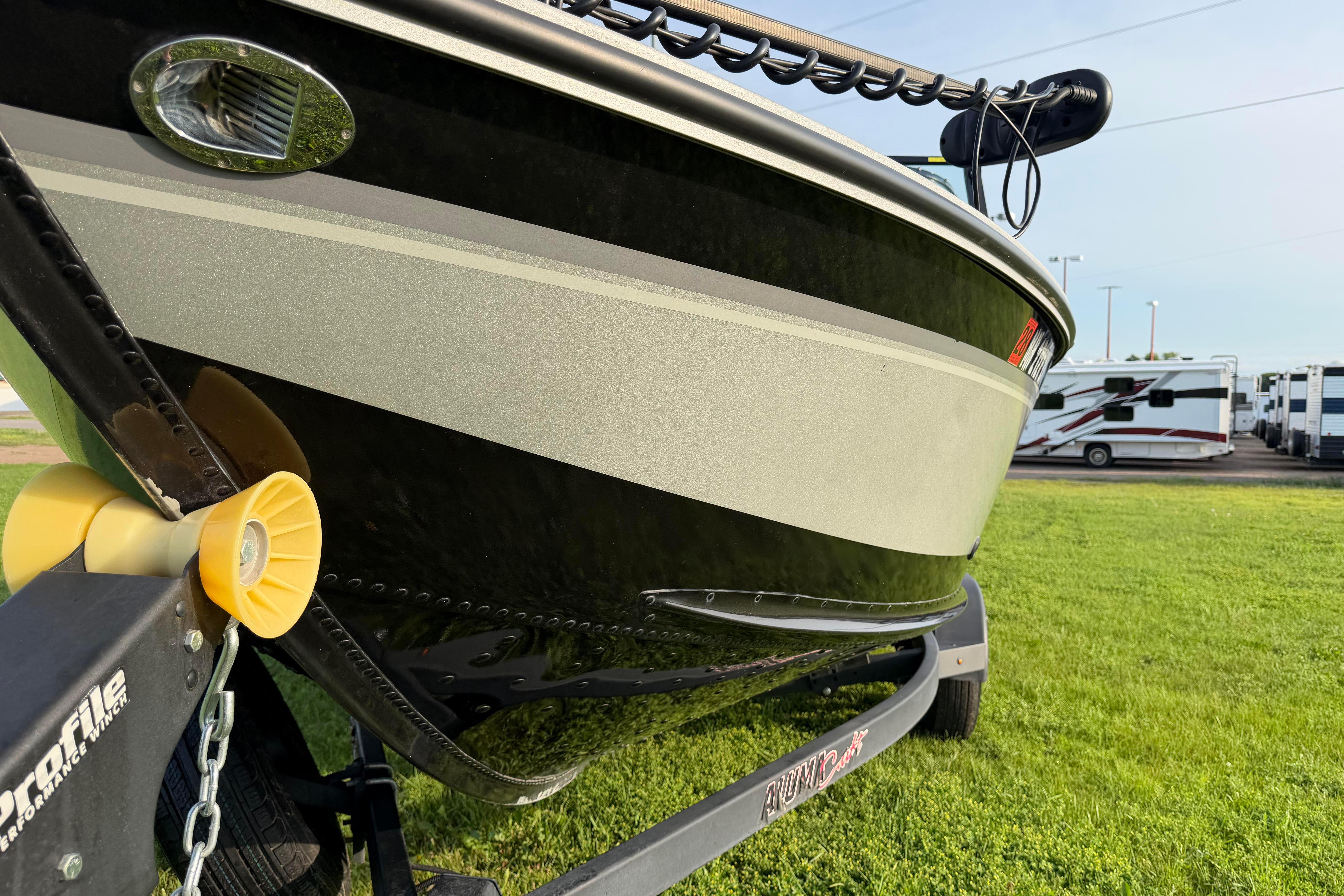2019 Alumacraft Trophy 205 boat on trailer, parked on grass with RVs in background.
