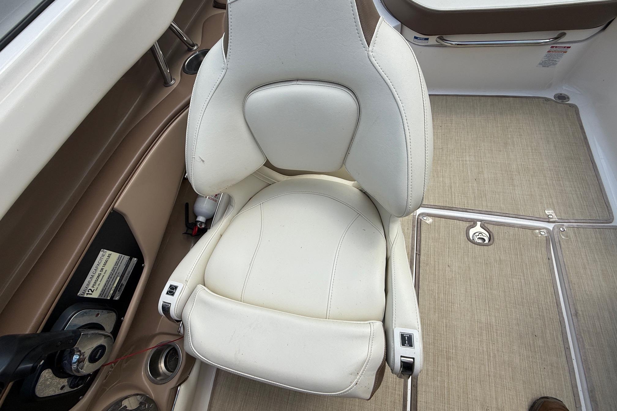 2016 Chaparral 226 SSi Wide Tech boat interior with white captain's chair and beige flooring.