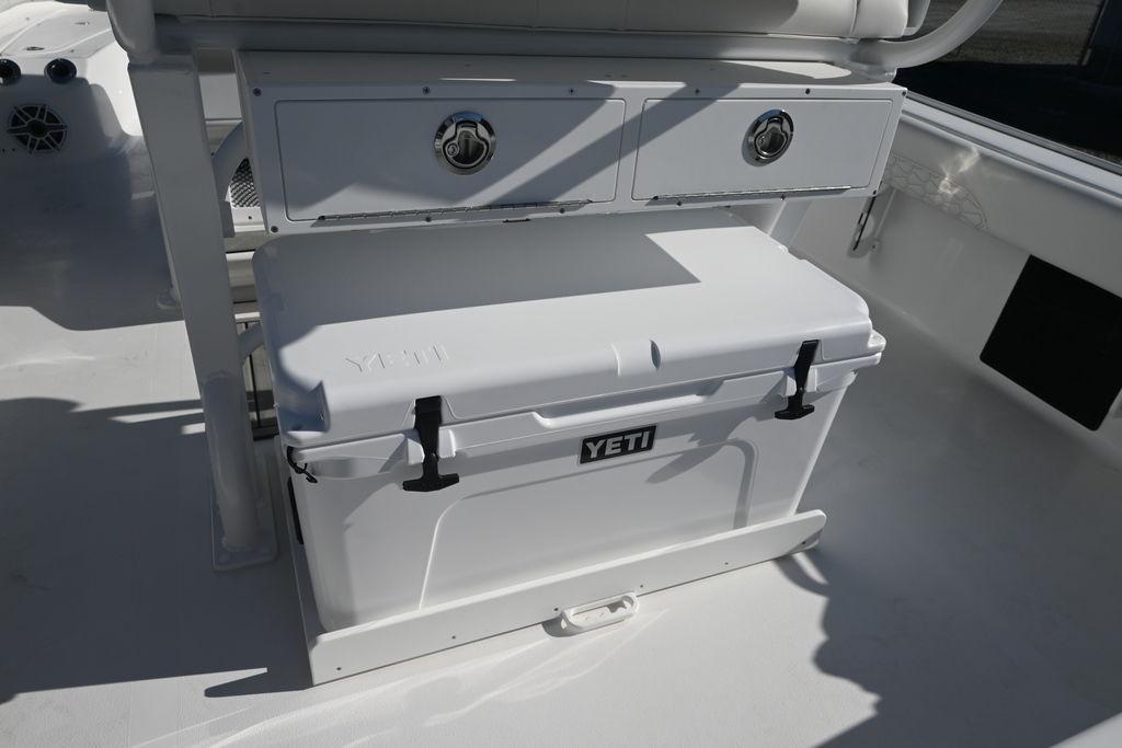 YETI cooler on 2026 Tidewater 2500 Carolina Bay boat deck, under storage compartment.