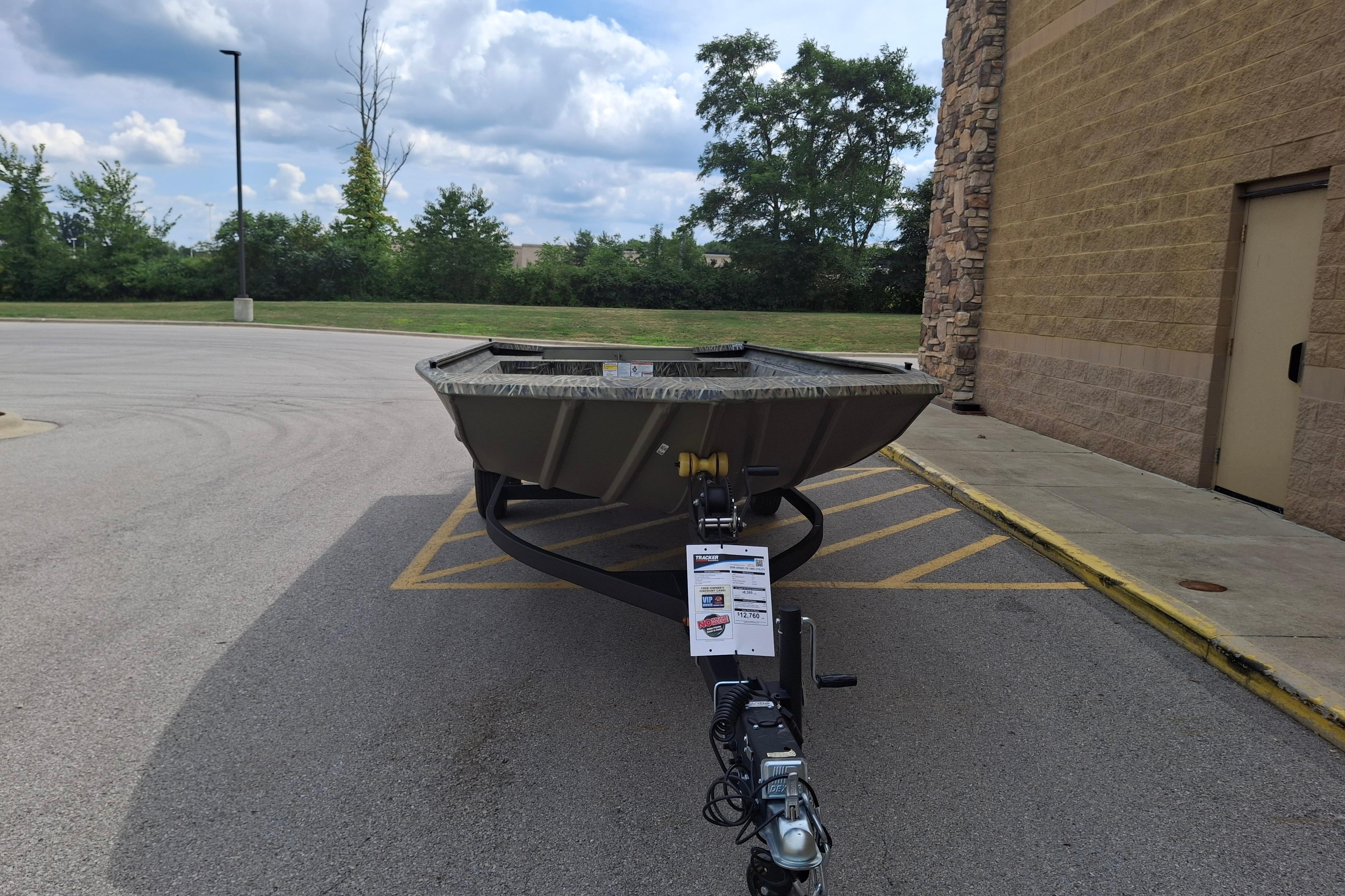 2026 Tracker Grizzly 1860 Utility boat parked outdoors on a sunny day.