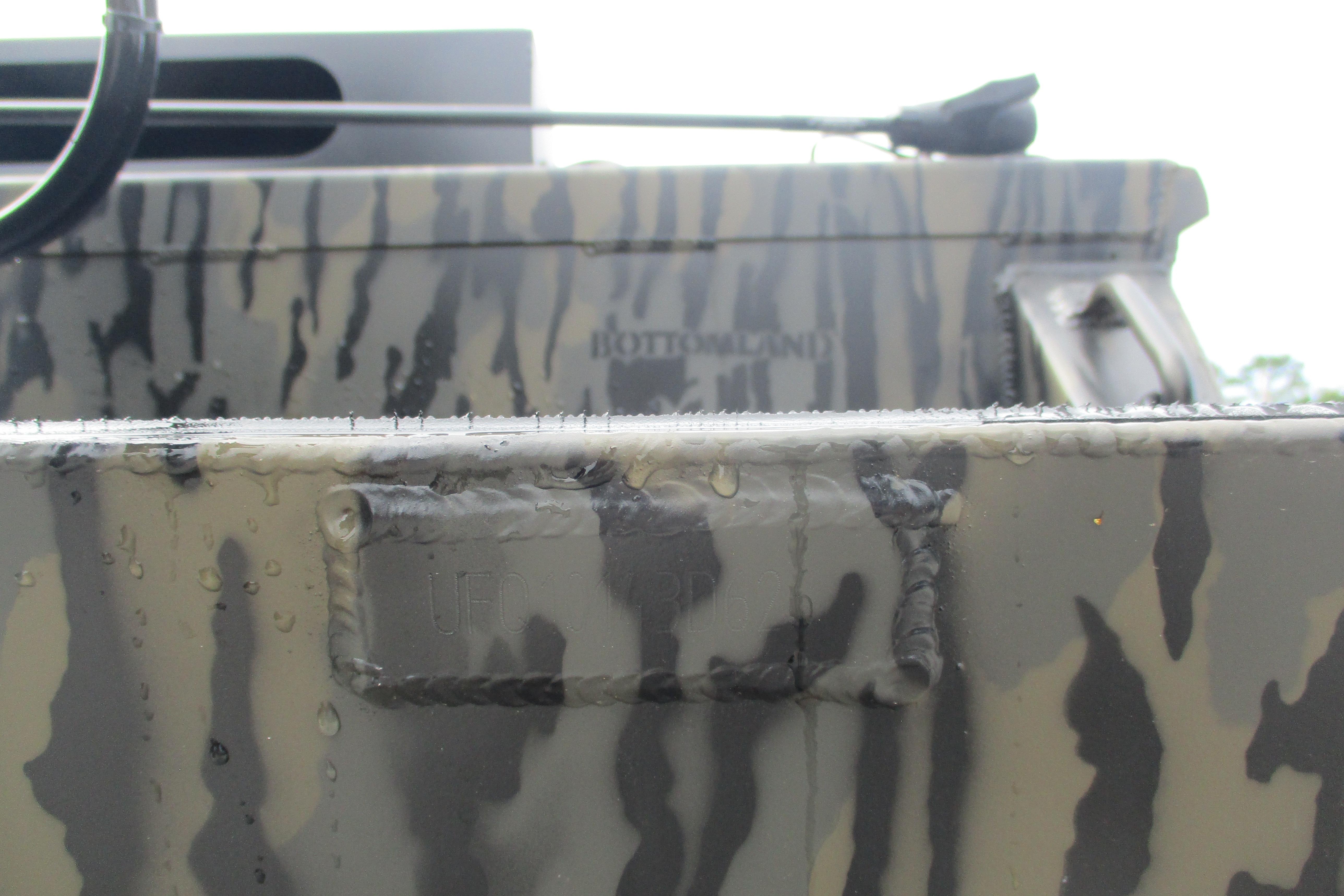 Close-up of 2026 Gator Tail 2060 Extreme CC boat with camouflage pattern and water droplets.