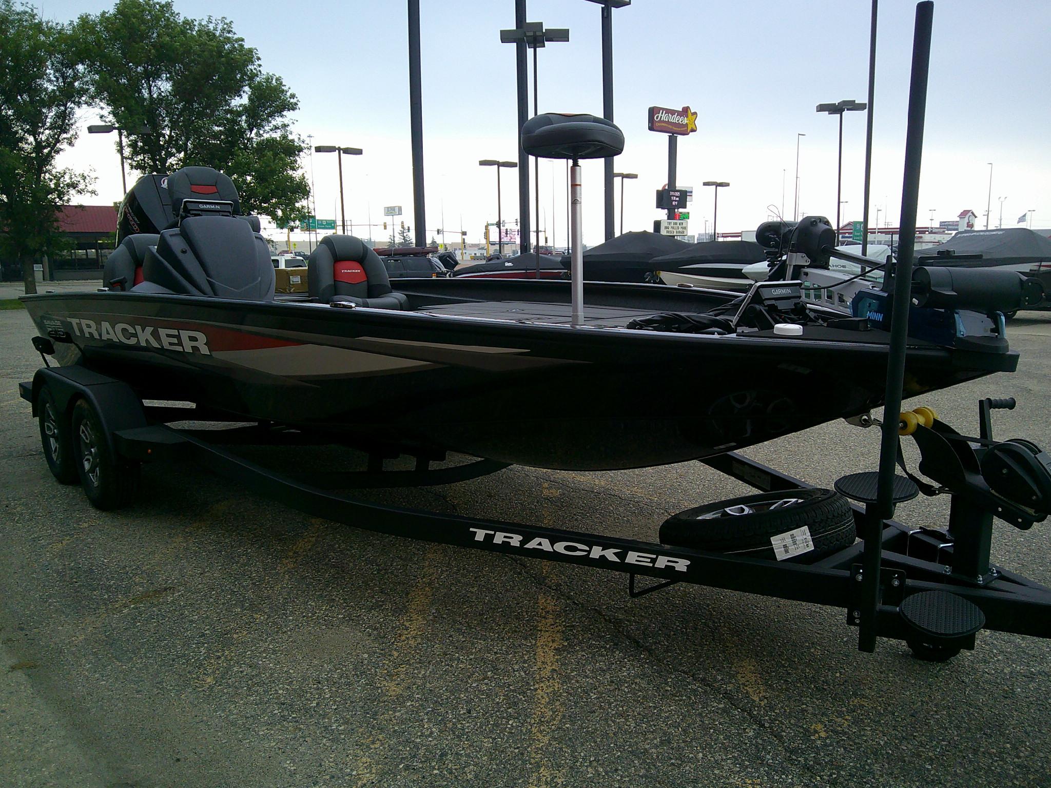 2025 Tracker Savage 215 boat on trailer in parking lot.