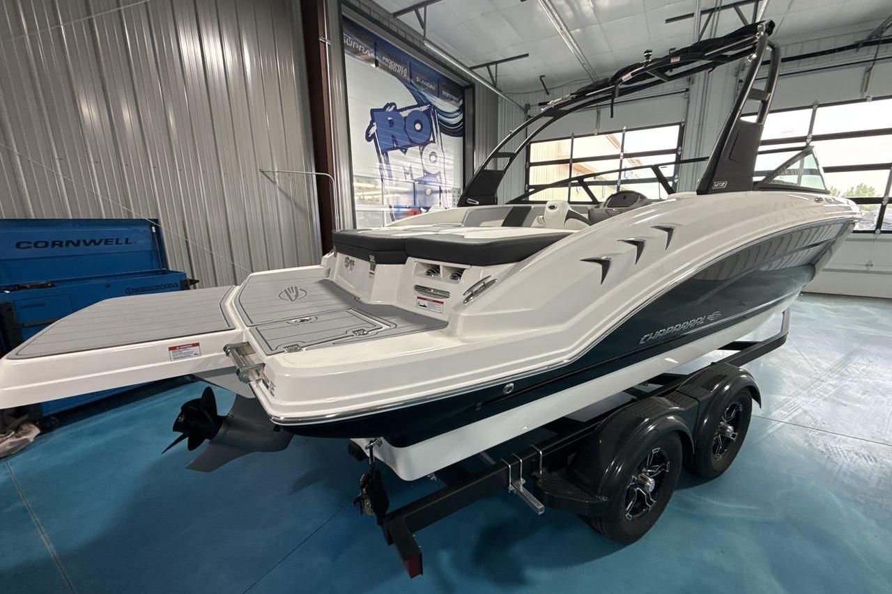 The image shows a Chaparral 23 SSi boat in a showroom on a trailer.