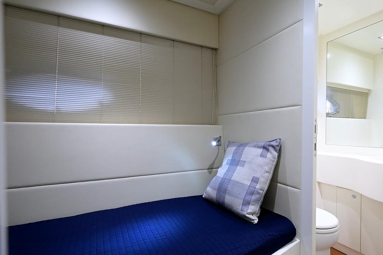 Luxurious cabin interior of 2015 Pershing 92 yacht with modern design and cozy bedding.