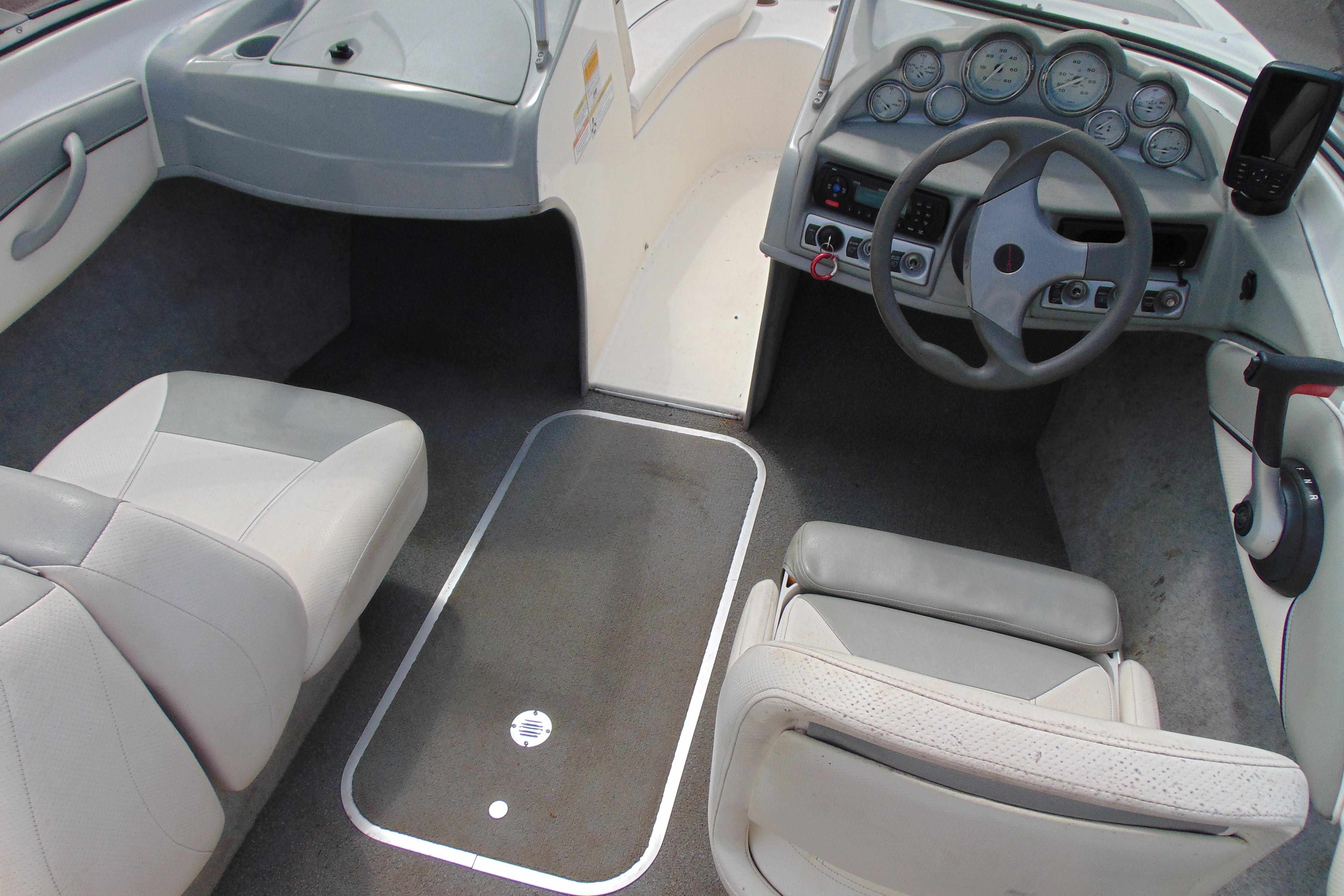 Interior view of a 2012 Bayliner 185 Bowrider boat cockpit with steering wheel and seating.