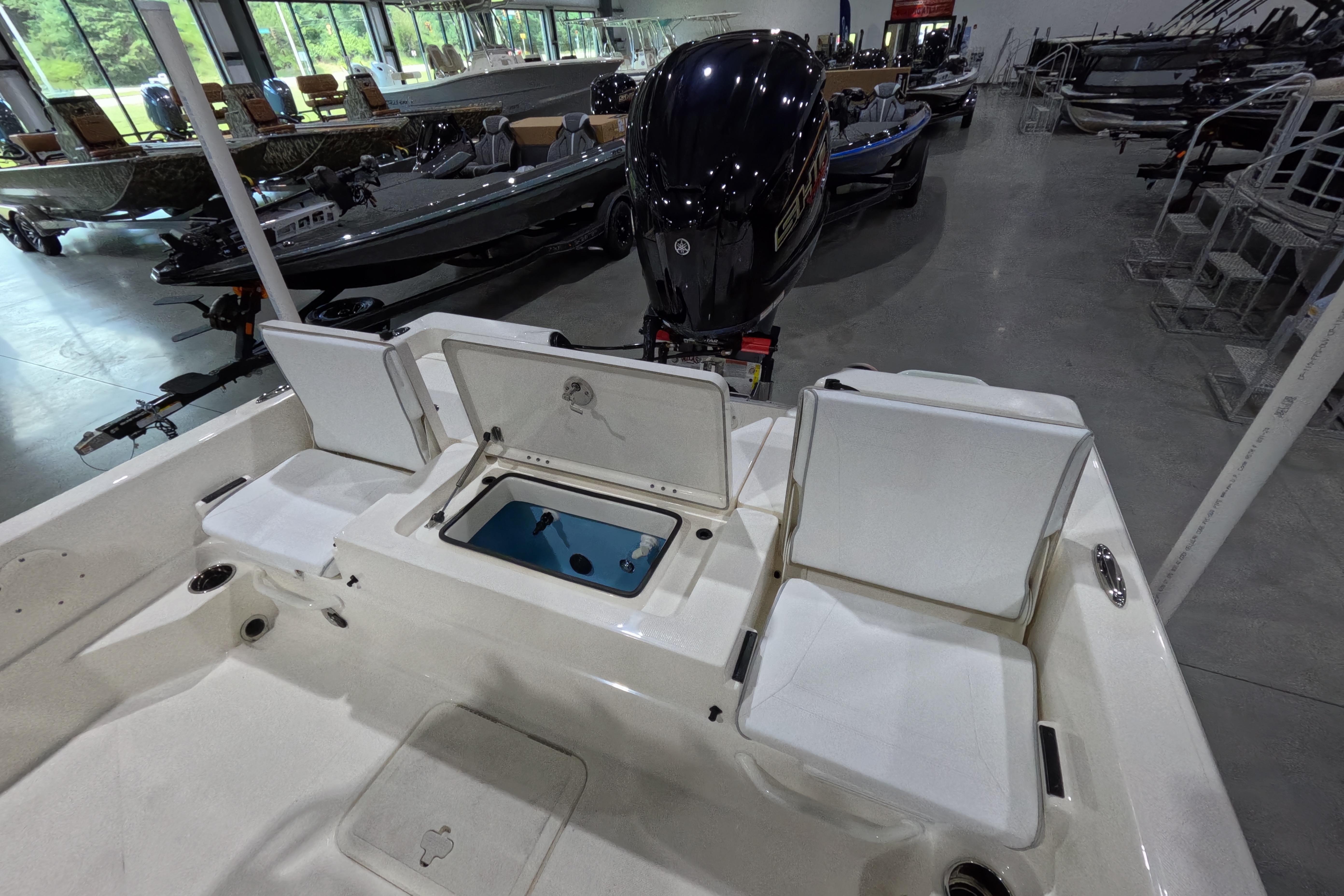 2026 Skeeter SX230 boat interior with seating and storage, displayed in a showroom.