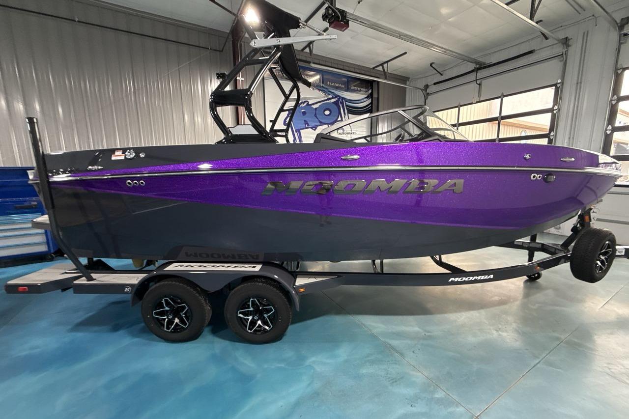A purple 2026 Moomba Craz boat on a trailer inside a warehouse.