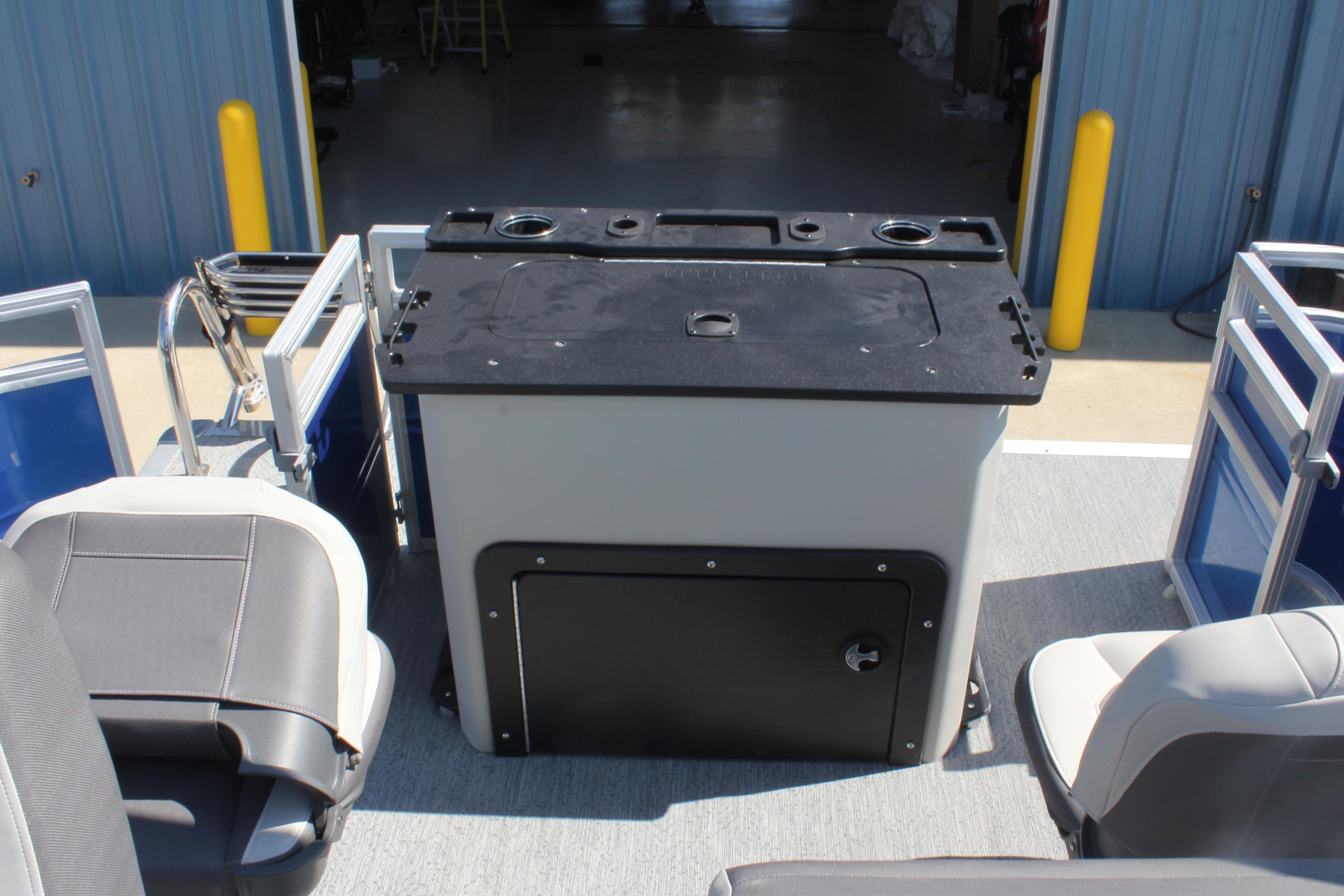 2026 Sun Tracker Fishin' Barge 20 DLX interior with seating and storage unit.