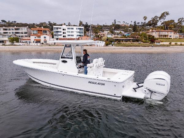2025 Regulator 28 boat on calm water near coastal homes.