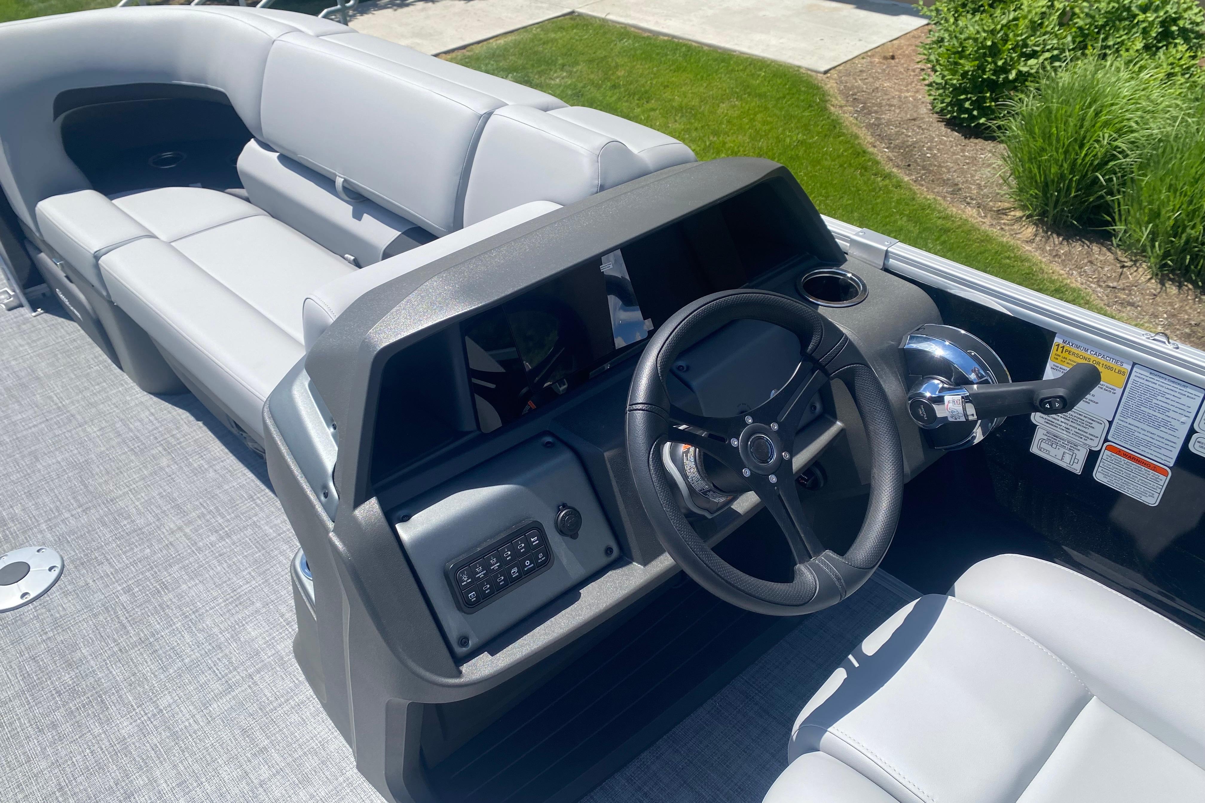 2026 Sun Tracker Party Barge 22 RF DLX interior with steering wheel and seating.