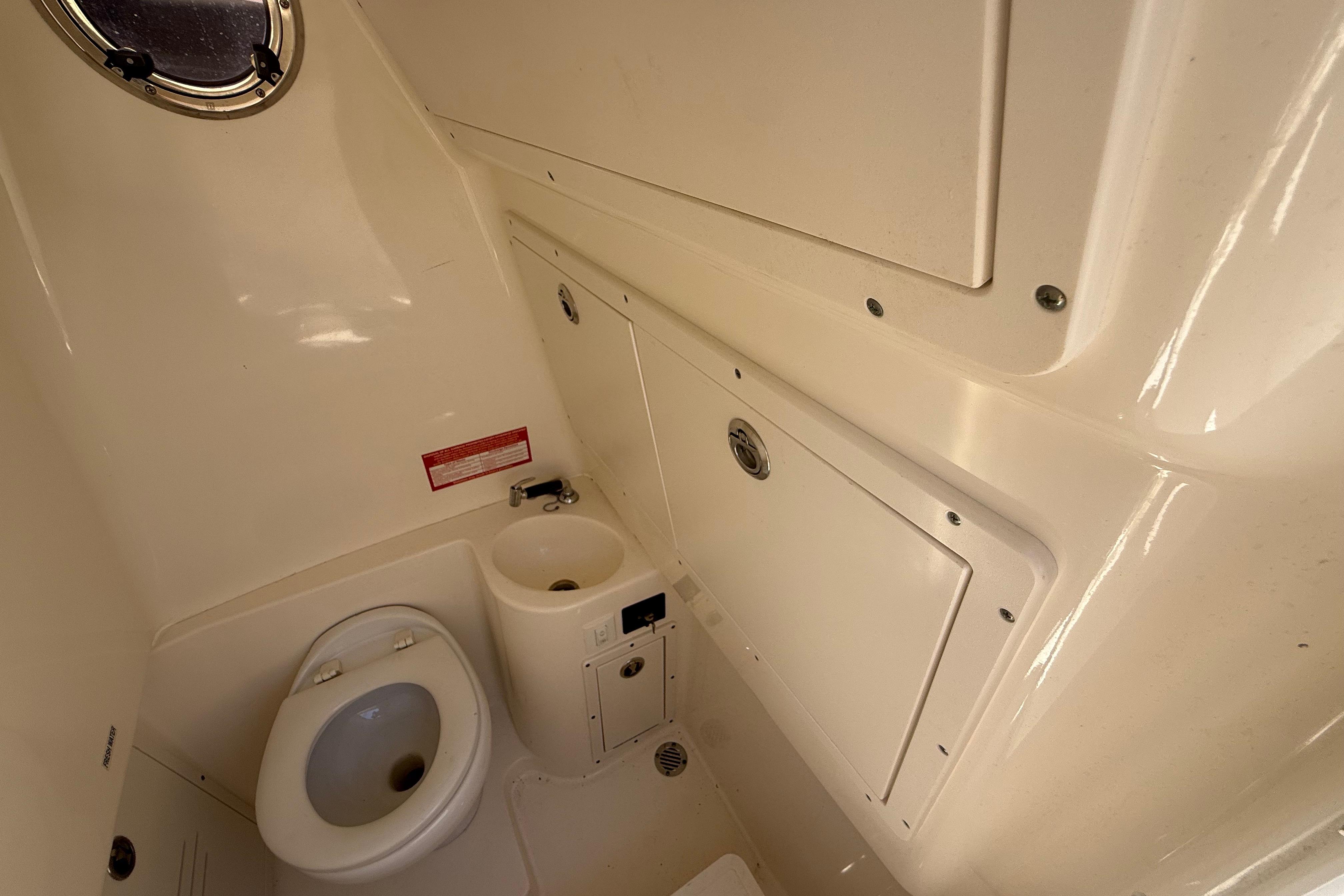 Interior of 2019 Key West Billistic 281 Center Console boat bathroom with toilet and sink.