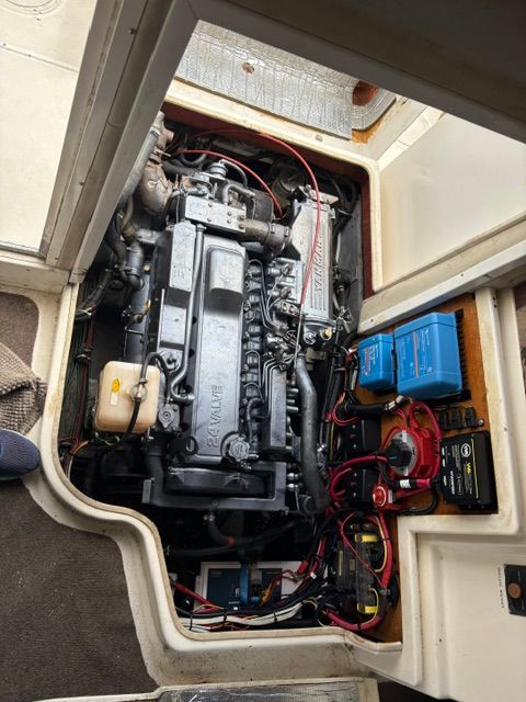 Boat engine compartment with a large engine and electrical components.