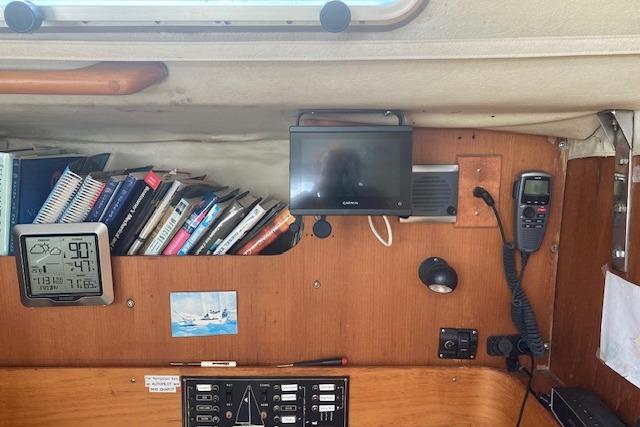 Interior of 1988 Westerly Corsair 36 sailboat with navigation equipment and bookshelf.