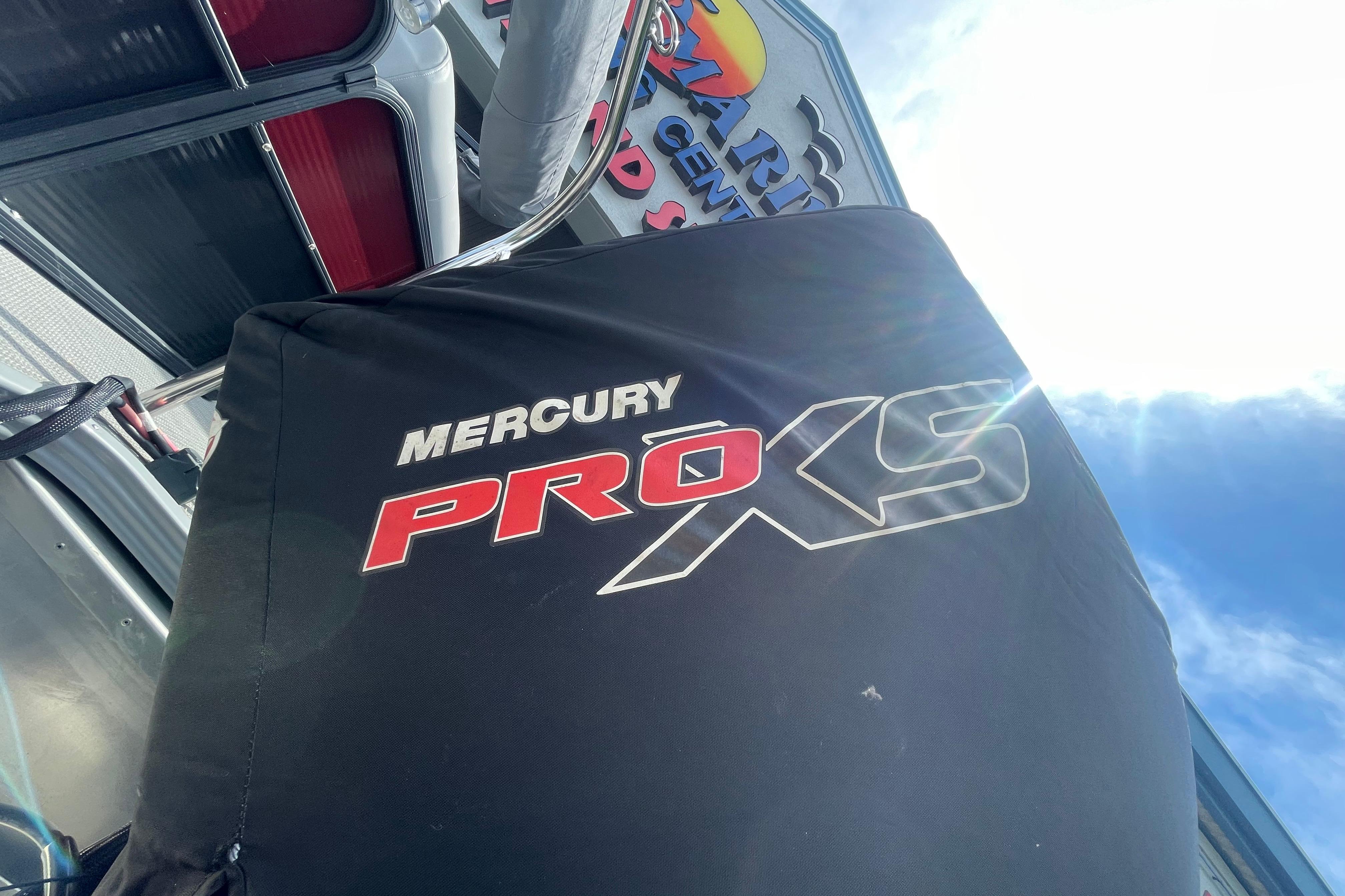 Mercury Pro XS engine cover on 2022 Manitou 23 Oasis boat under bright sky.