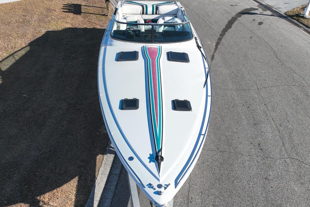 1989 Formula 292 SR-1 boat with colorful stripes, parked on a road.