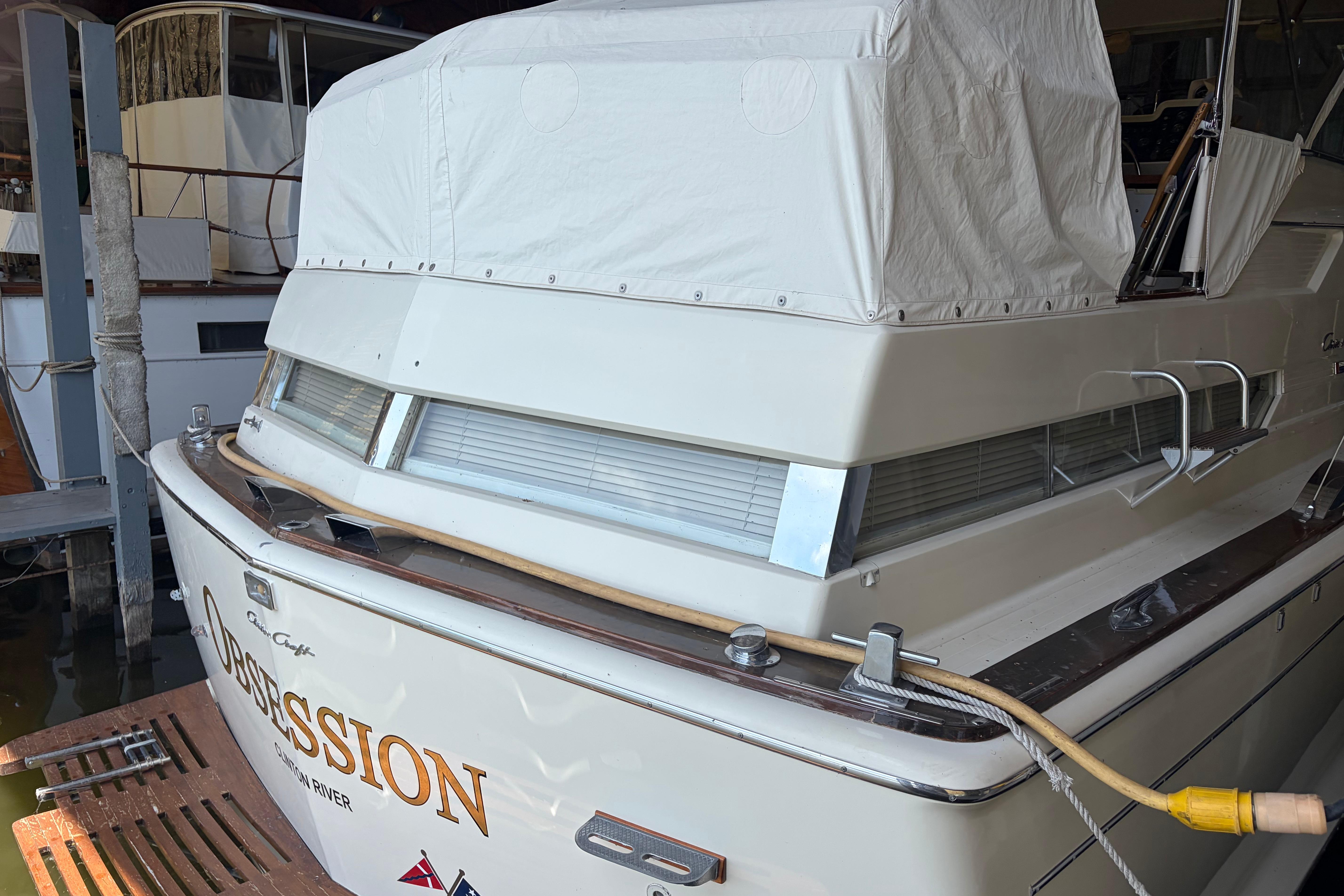 1971 Chris-Craft 42 Commander boat docked, covered, with "Obsession" name visible.