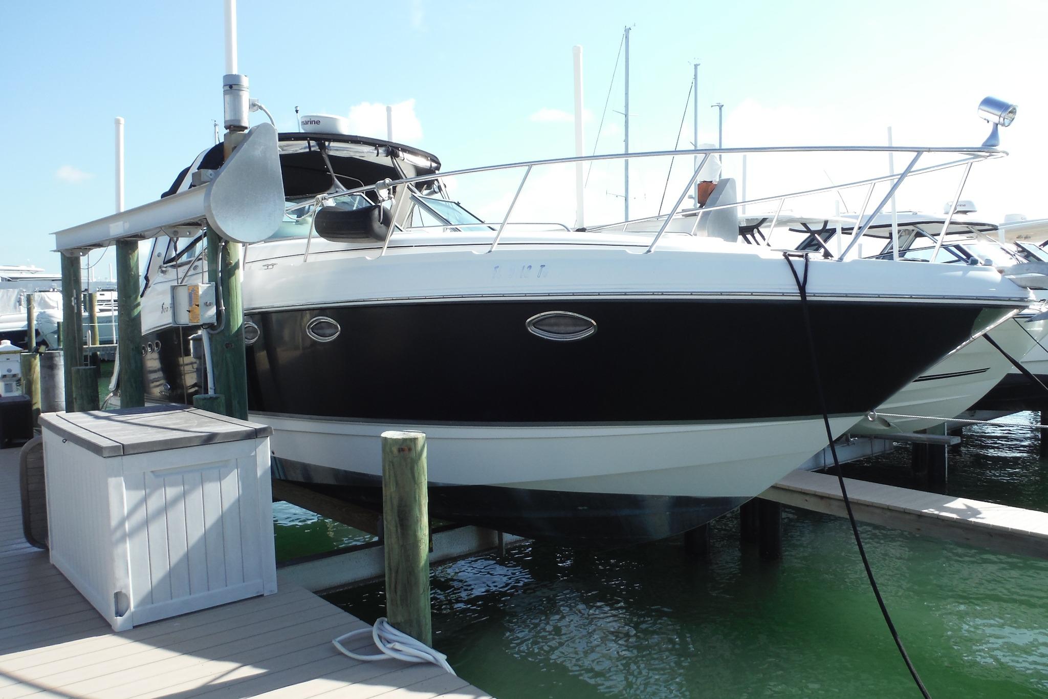 2005 Chaparral Signature 350 boat docked at marina, featuring sleek black and white design.