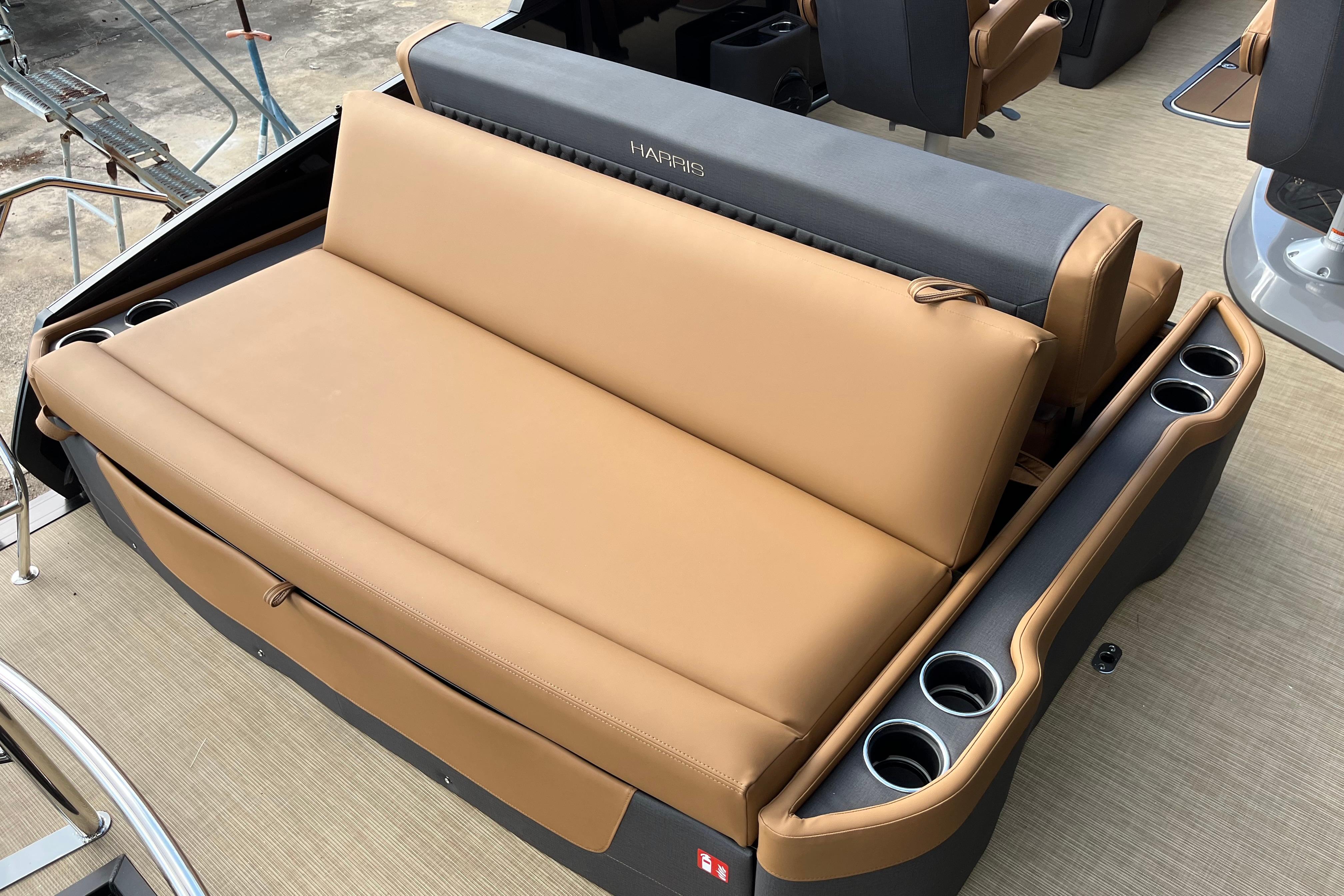 2025 Harris Sunliner 250 boat interior with tan seating and cup holders.