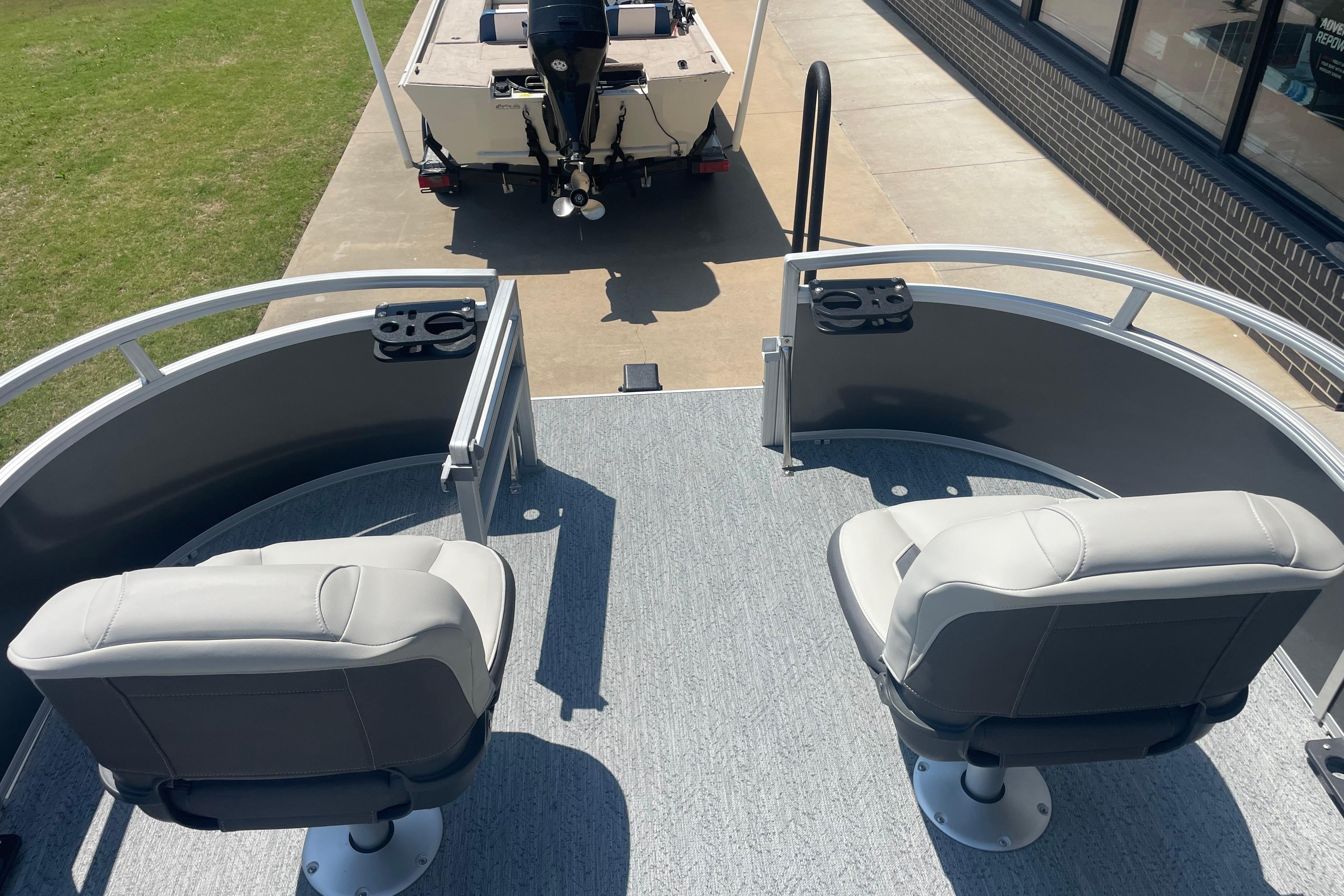 2026 Sun Tracker Bass Buggy 16 XL Select pontoon boat with dual seats and motor.