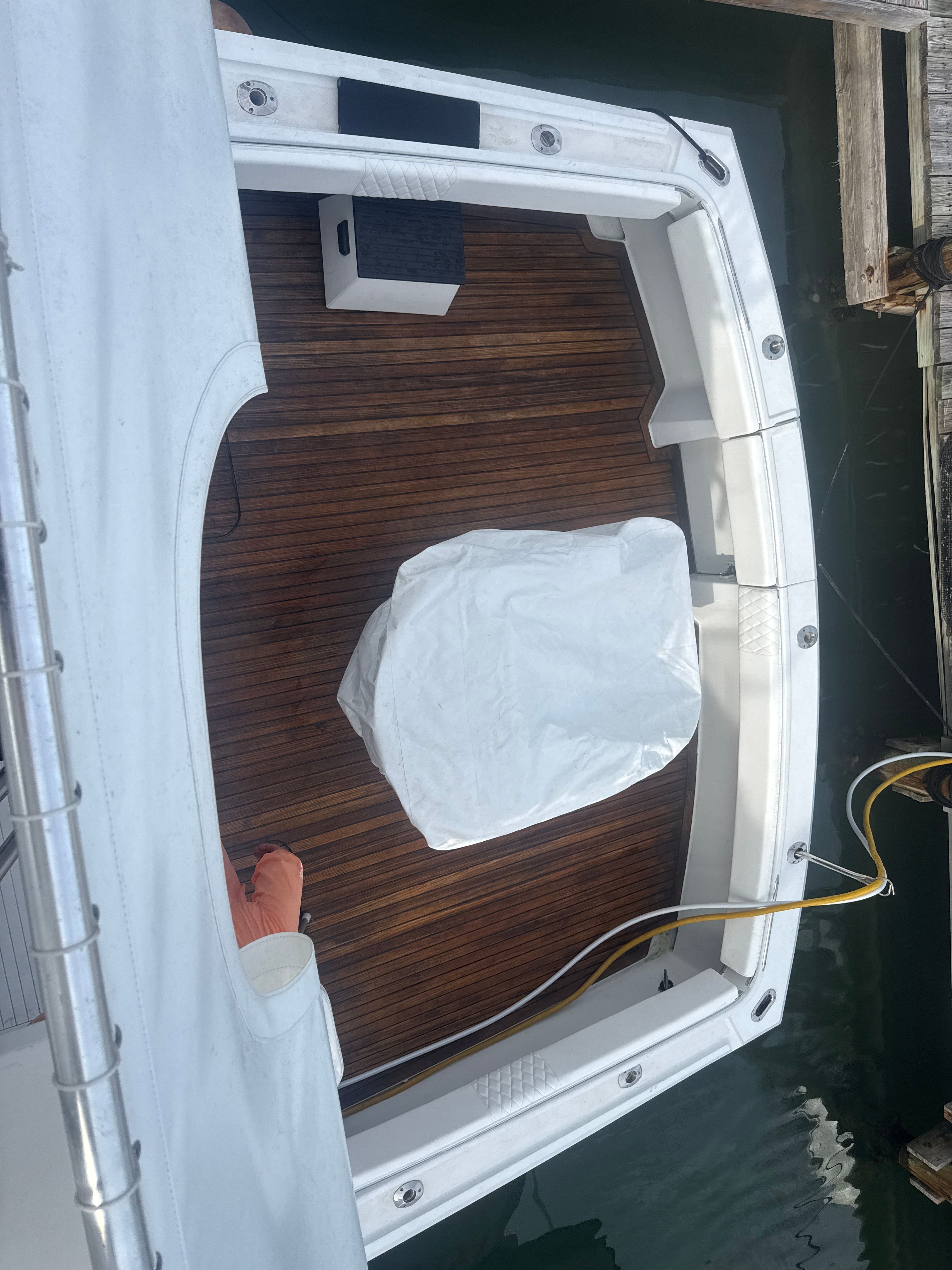 The image shows the deck of a 1979 Hatteras sport fishing boat with wooden flooring.