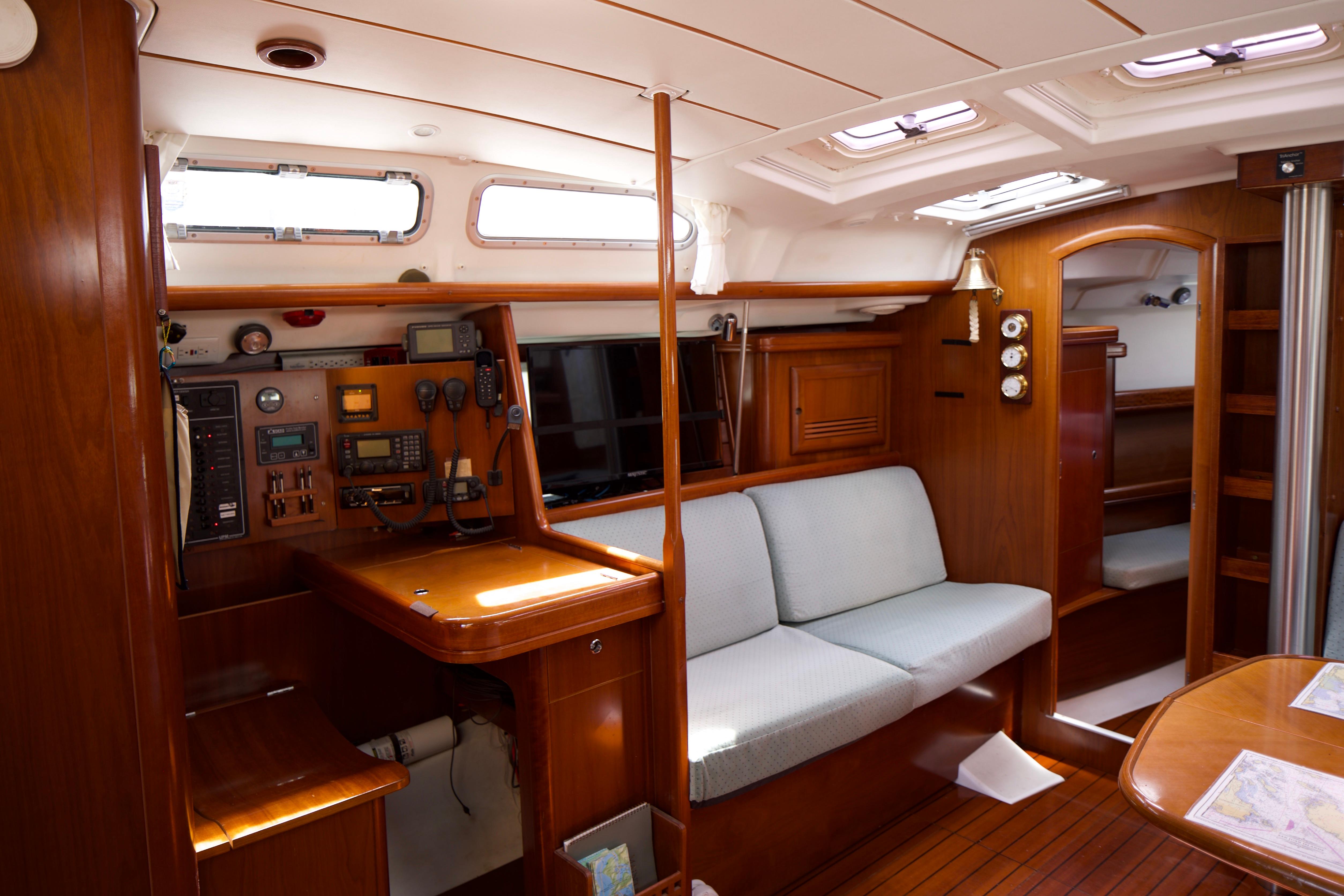 Interior of 2005 Beneteau 423 sailboat with navigation station and cozy seating area.