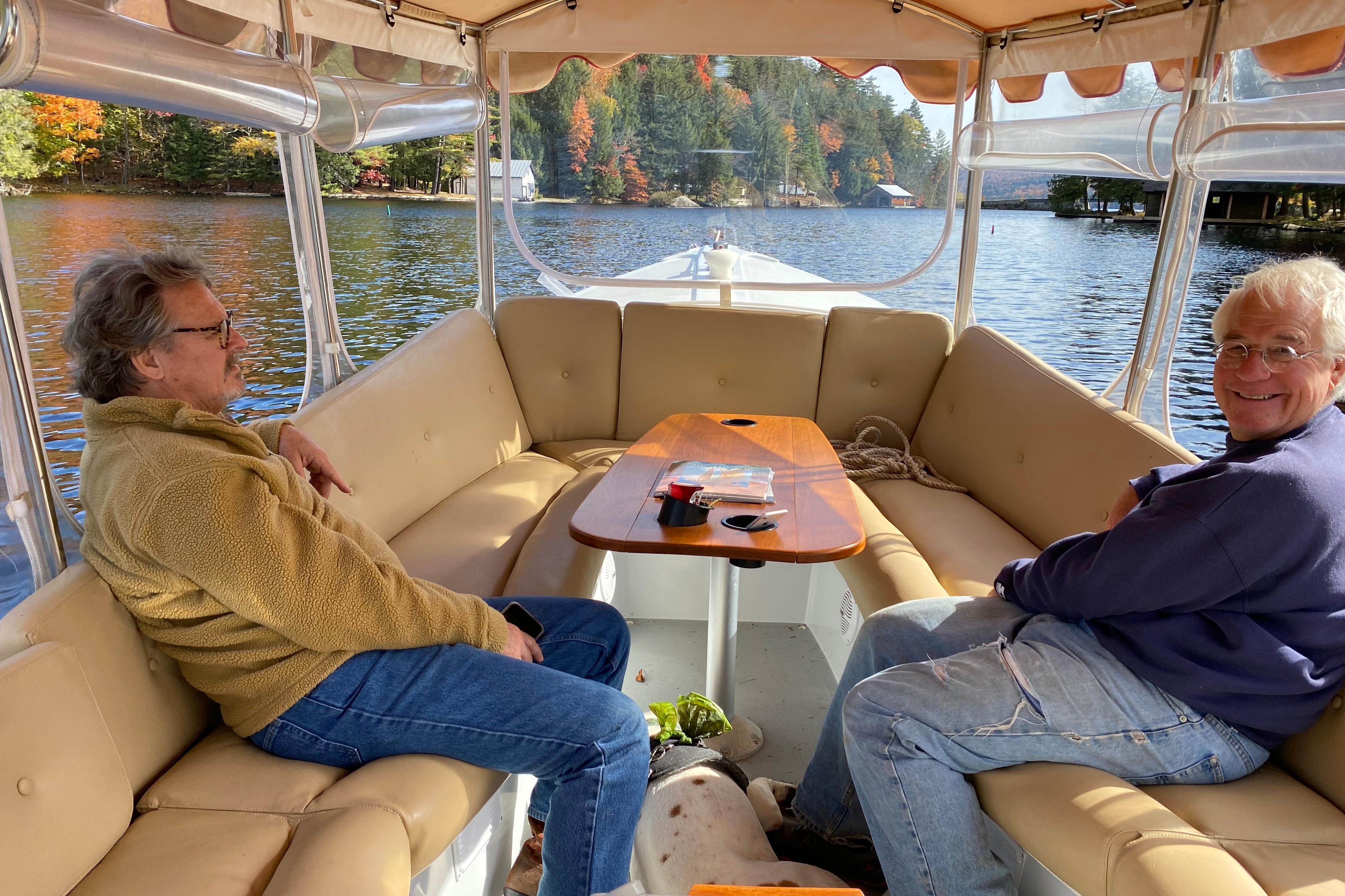 Two people relaxing on a 2004 Duffy 21 Classic boat on a scenic lake.
