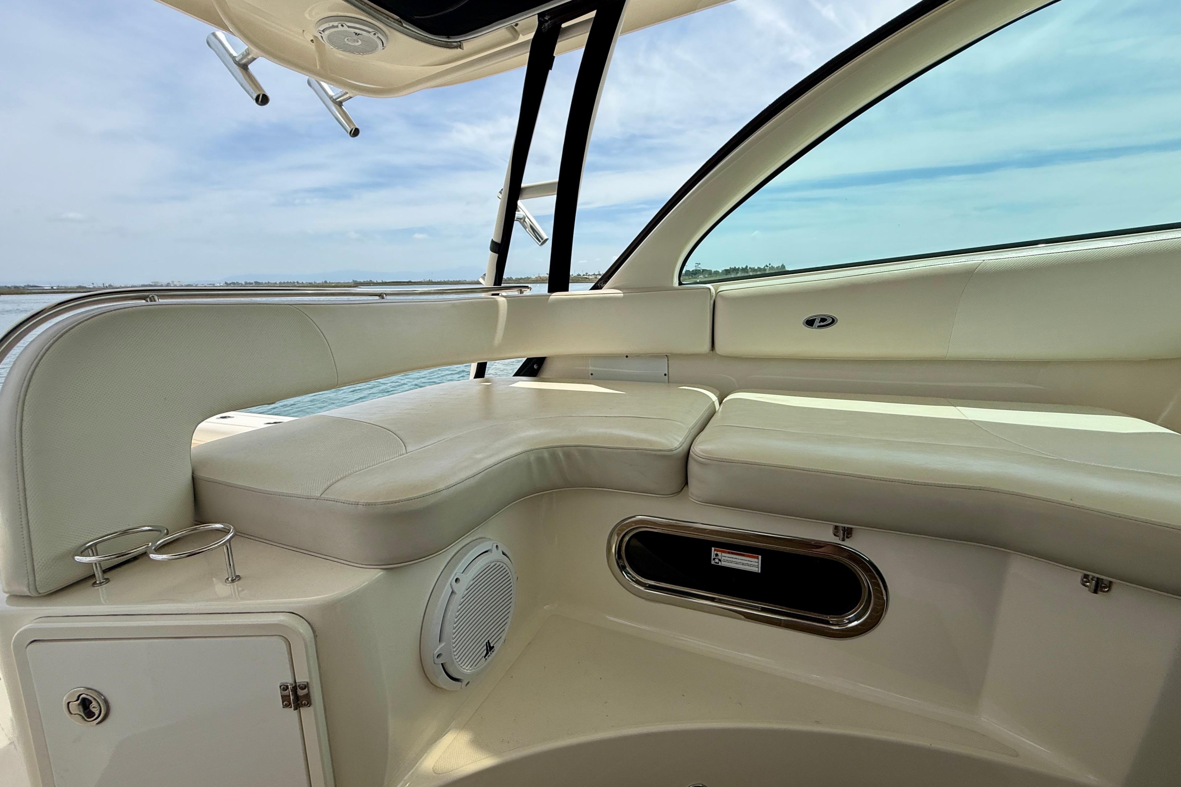 Interior view of 2012 Pursuit OS 345 Offshore boat with white seating and ocean backdrop.