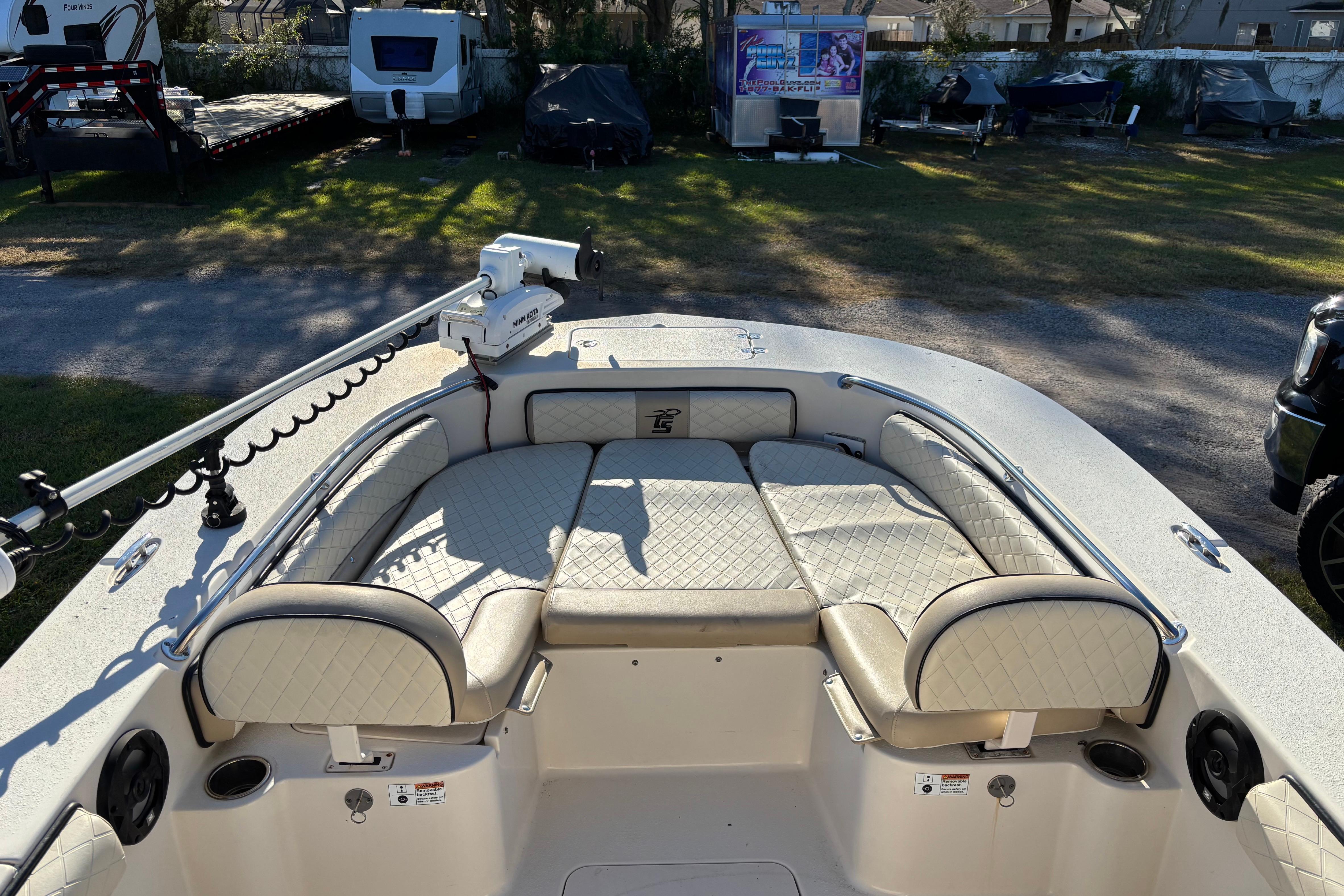 2021 Carolina Skiff 26 Ultra Elite boat with cushioned seating and trolling motor.