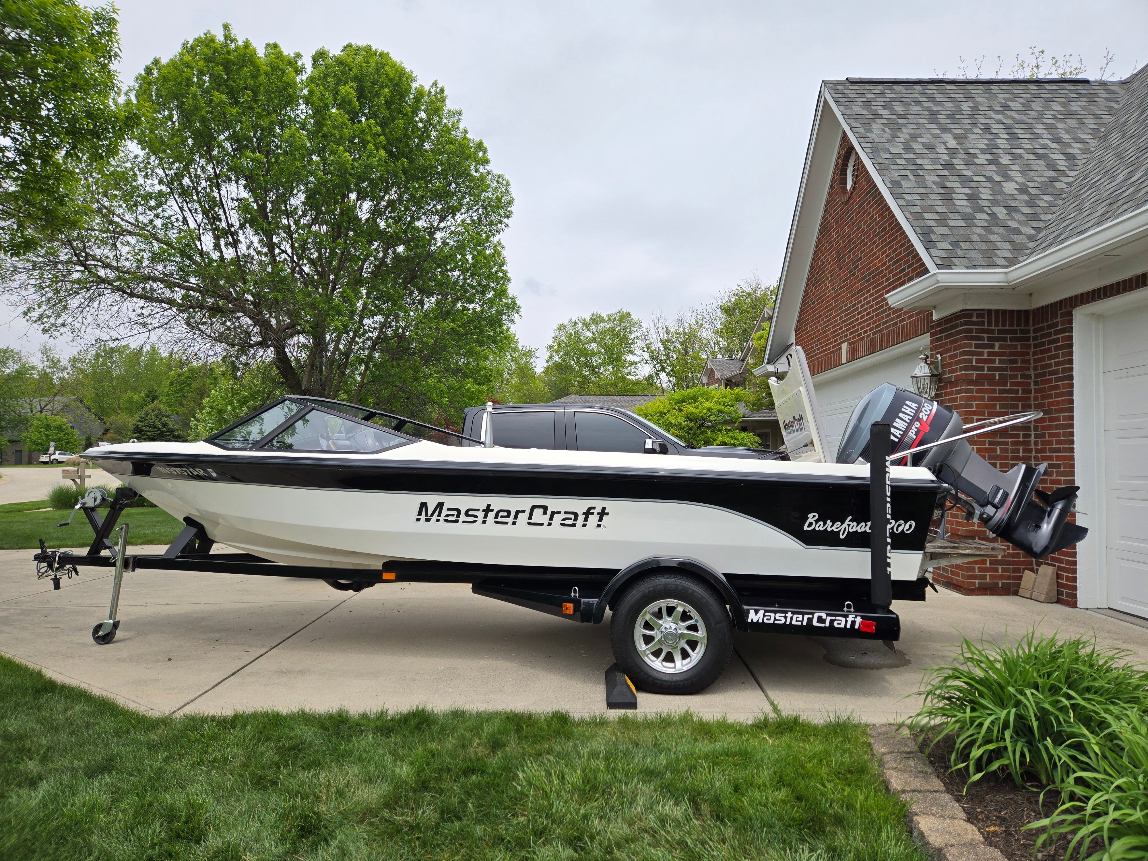 1991 MasterCraft Barefoot 200 boat on trailer in driveway.