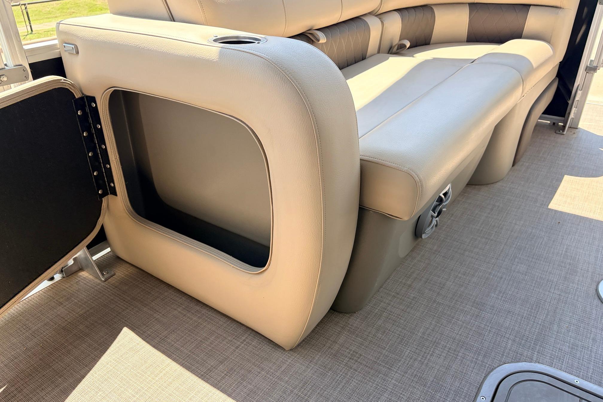 2024 Sun Tracker SportFish 22 XP3 boat interior with open storage compartment and cushioned seating.