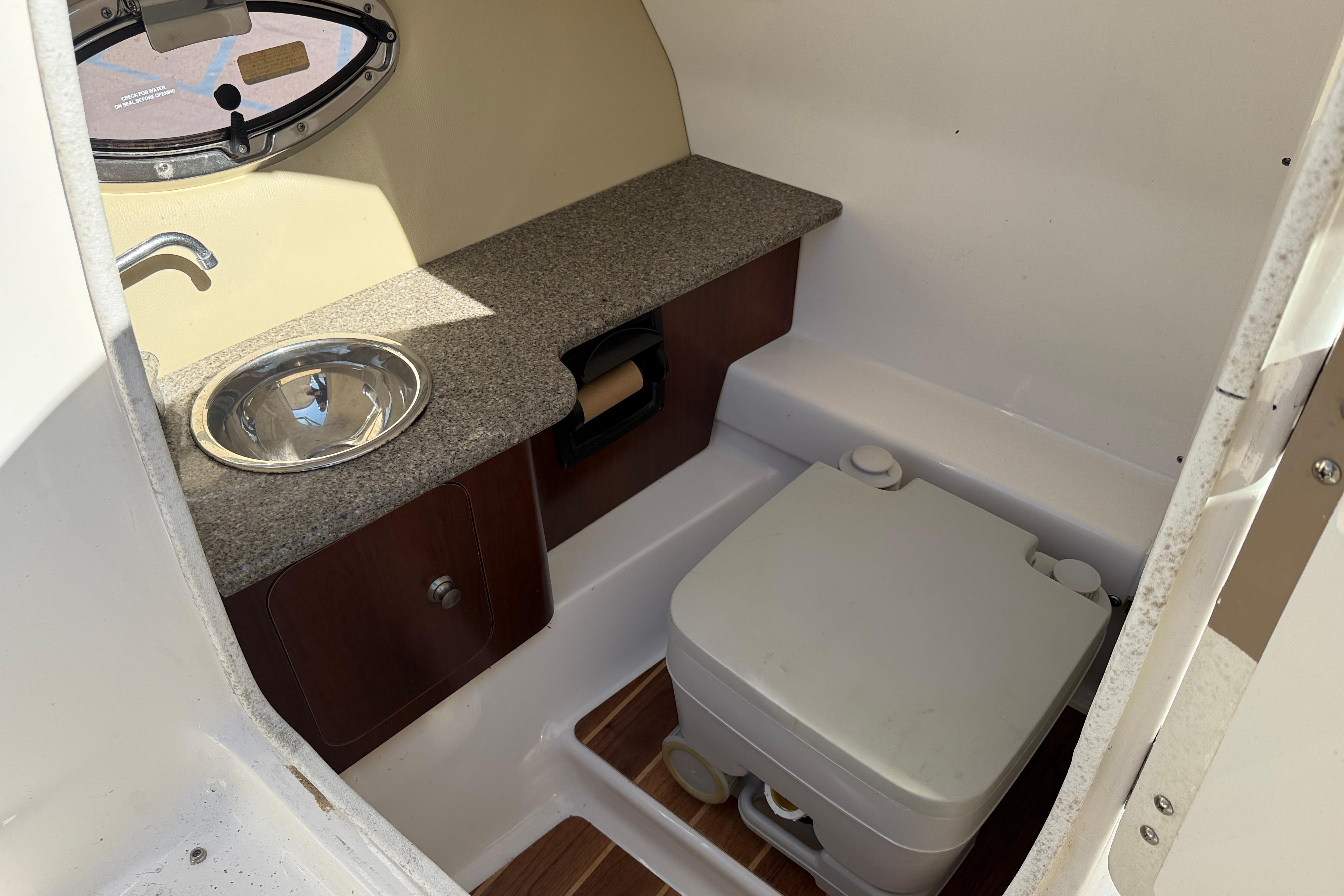 2014 Chaparral 264 Sunesta boat interior with sink and portable toilet.