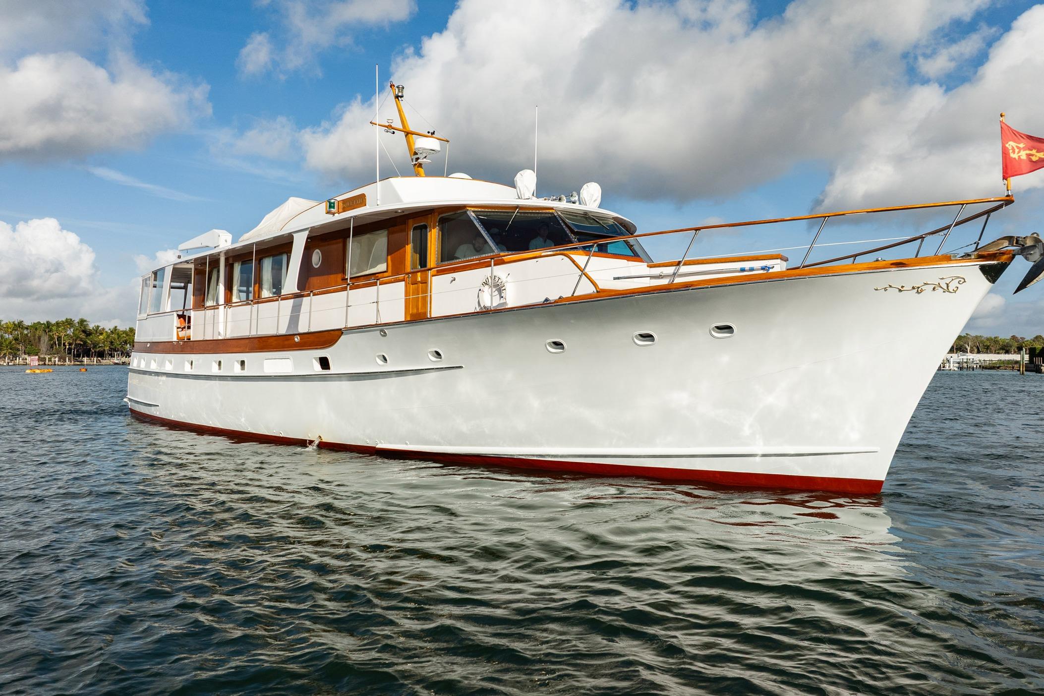1972 Trumpy 72 Motor Yacht on calm water under a partly cloudy sky.