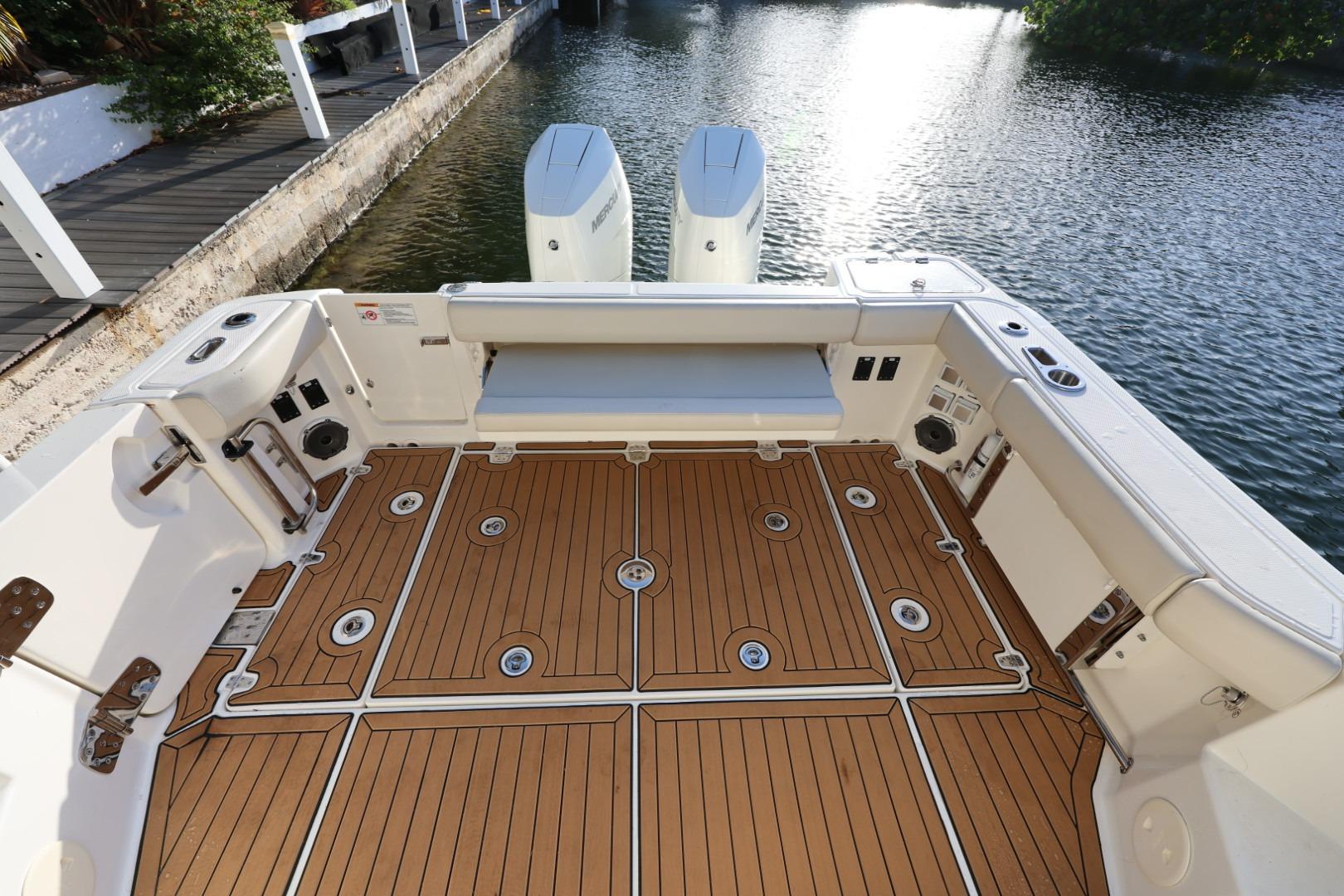 2025 Boston Whaler 325 Conquest boat deck with teak flooring by the water.