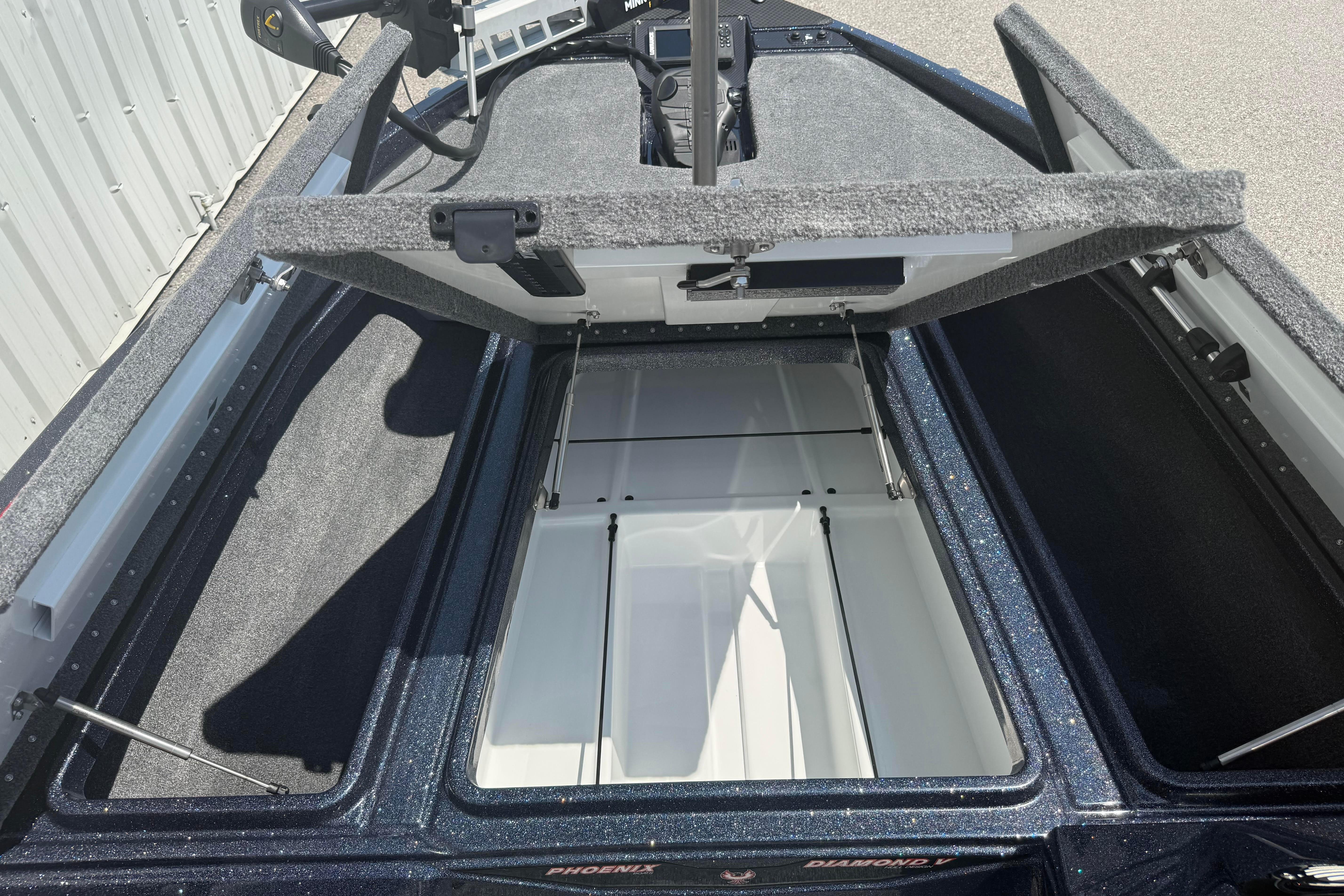 Open storage compartment of 2027 Phoenix 819 ZXL boat, showcasing interior space.