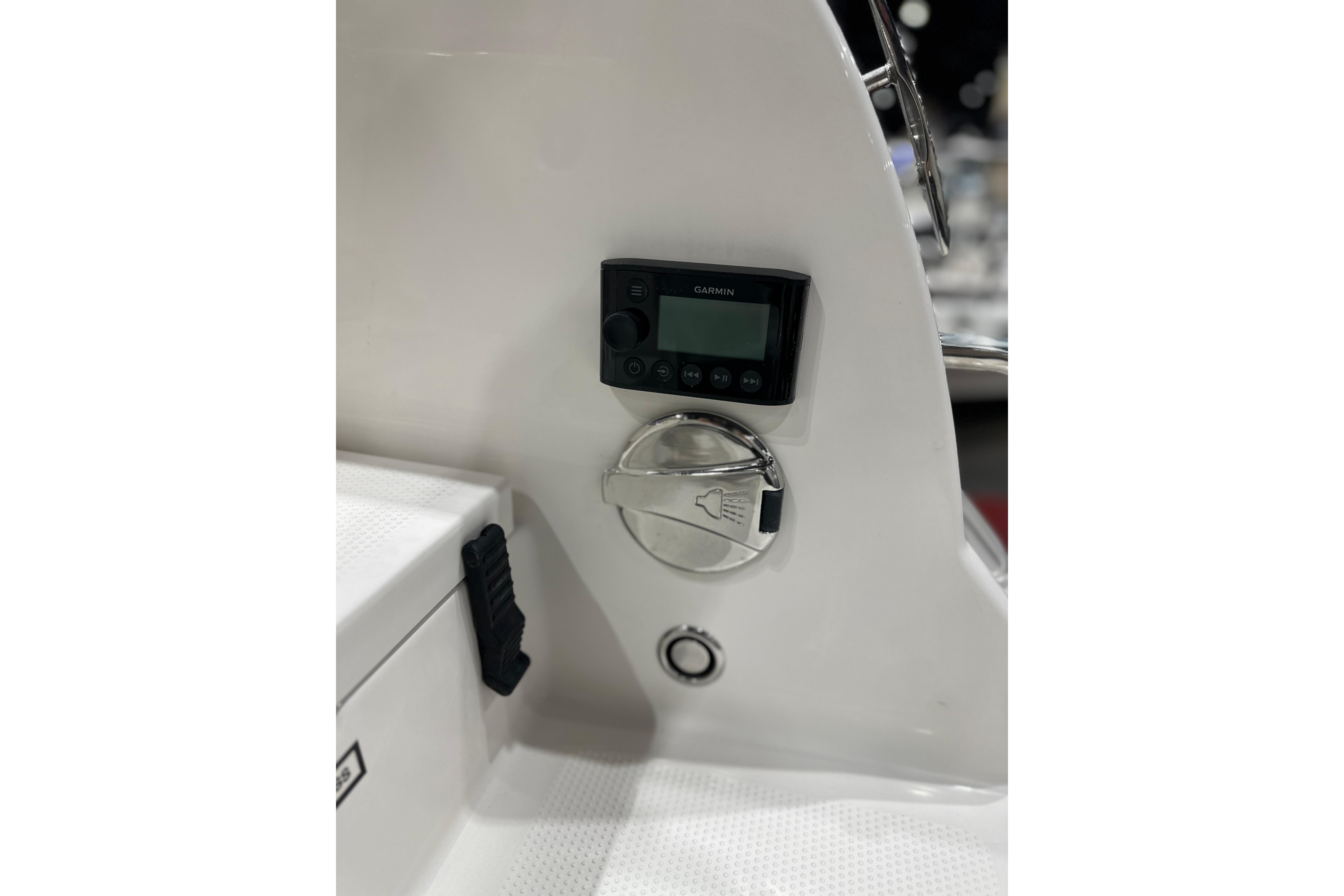 Control panel on 2026 Sailfish 232 CC boat featuring Garmin display and shower symbol.
