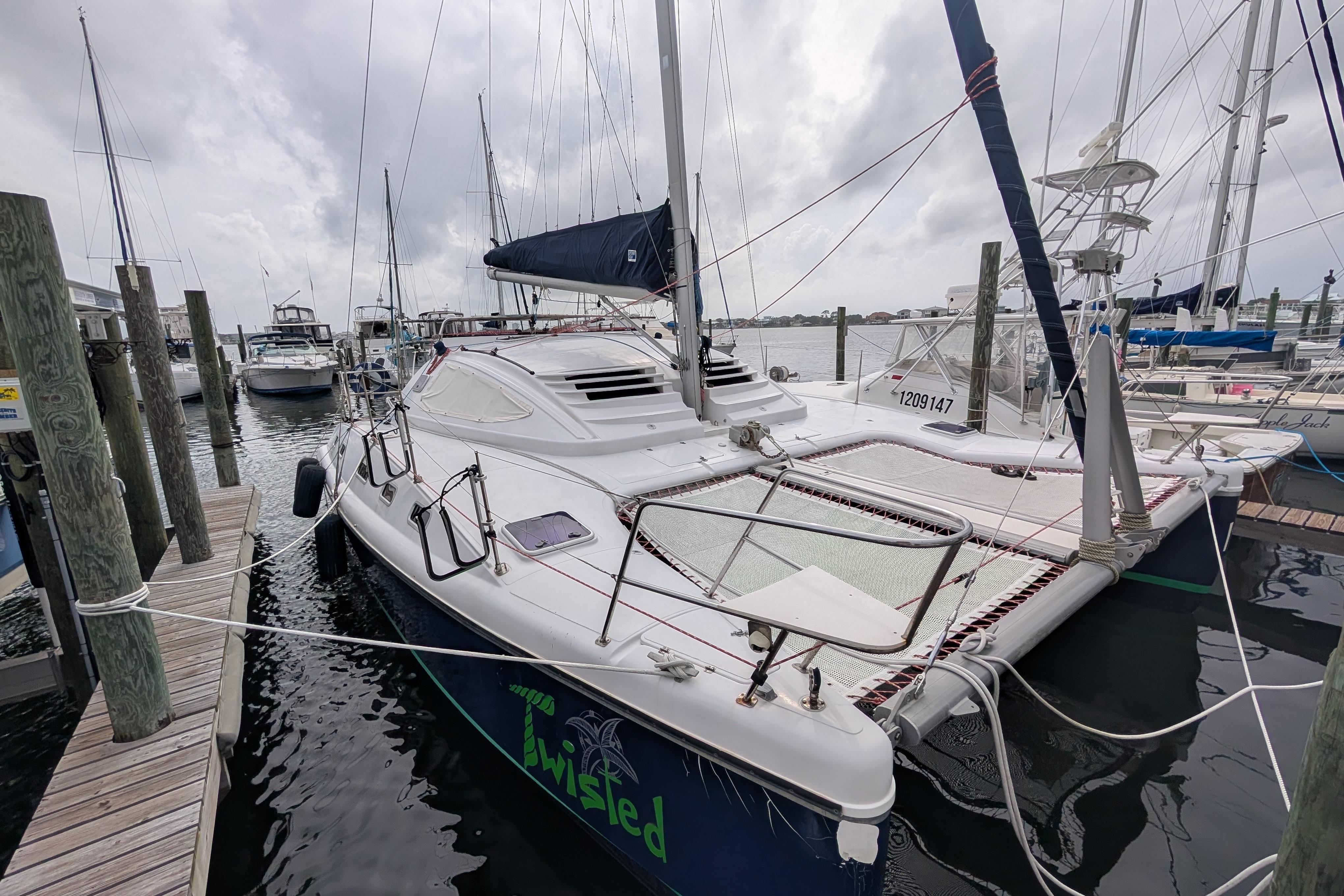 1999 Island Spirit 37 catamaran docked at marina under cloudy skies.