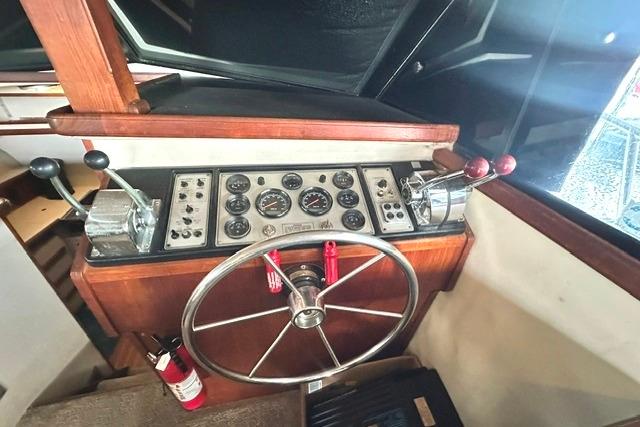 1989 Carver 32 Aft Cabin Motor Yacht helm with steering wheel and control panel.