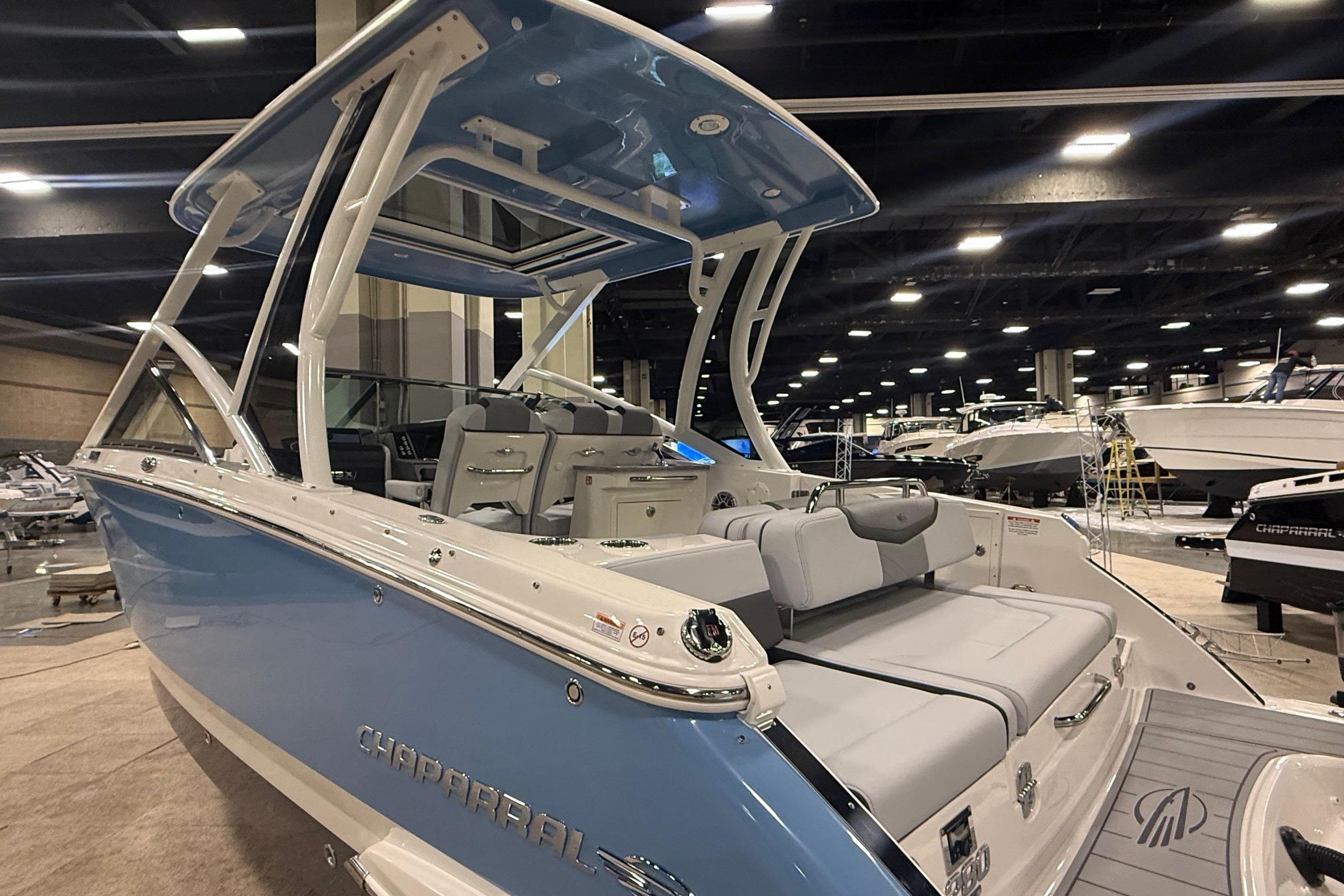 2026 Chaparral 280 OSX boat displayed indoors, featuring sleek design and spacious seating.