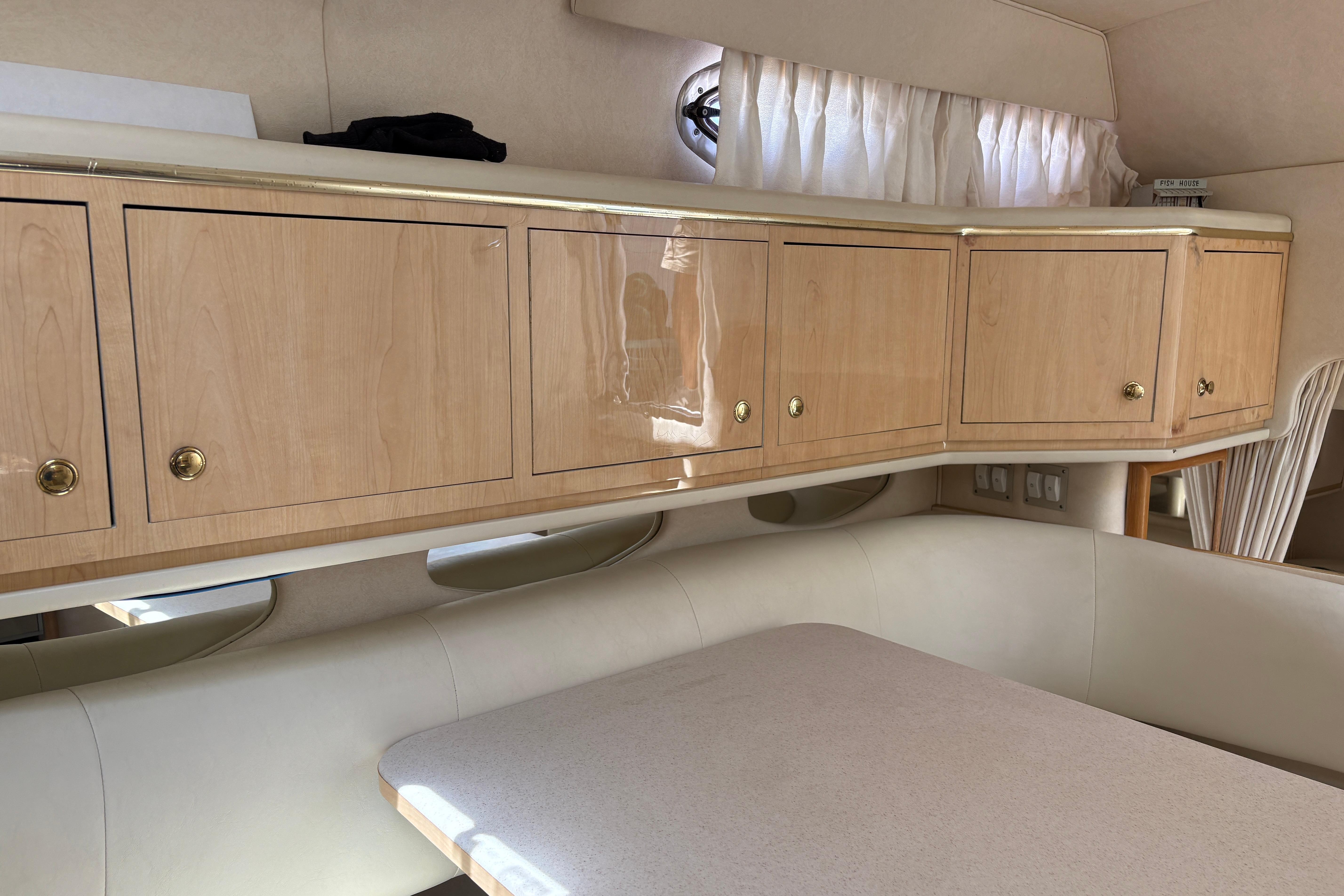 Interior of 2001 Sea Ray Sundancer 310 with wooden cabinets and dining area.