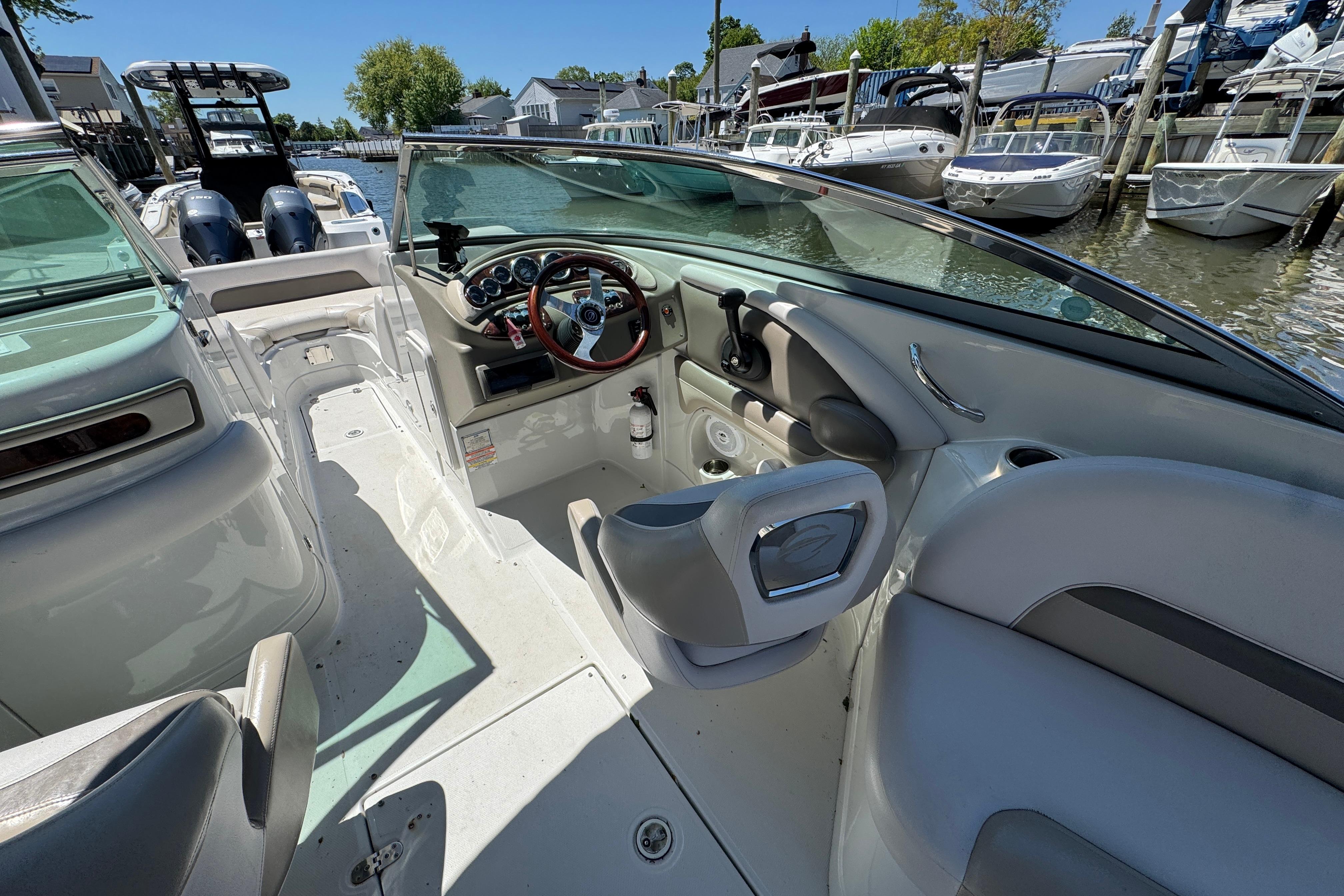 2013 Crownline Eclipse E6 XS boat interior with steering wheel and seating at a marina.