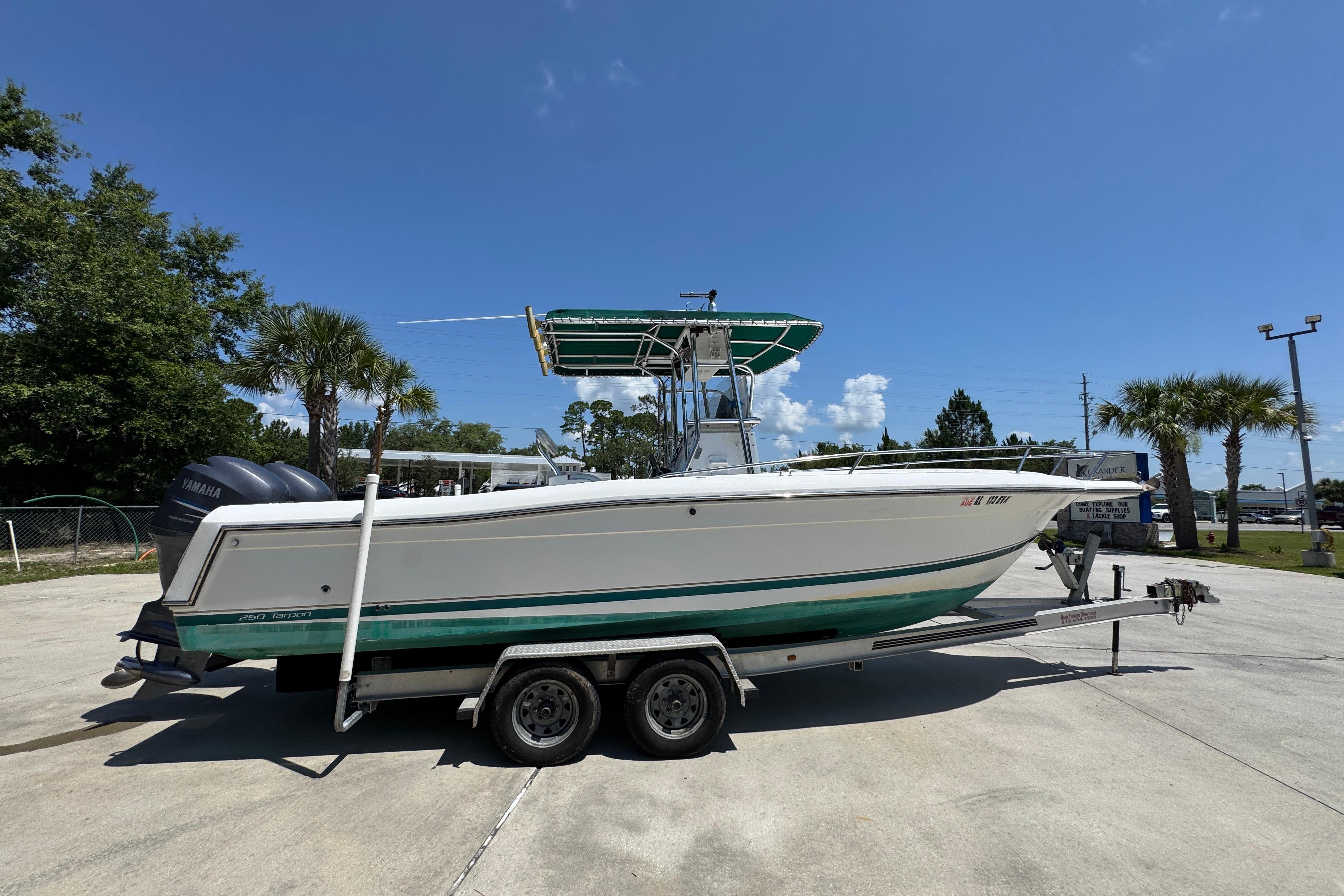 2000 Stamas 250 Tarpon boat on trailer, parked outdoors under clear blue sky.