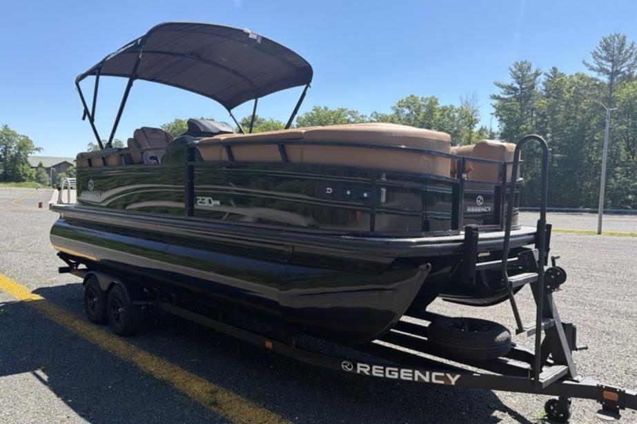 2026 Regency 230 DL pontoon boat on trailer, parked outdoors.