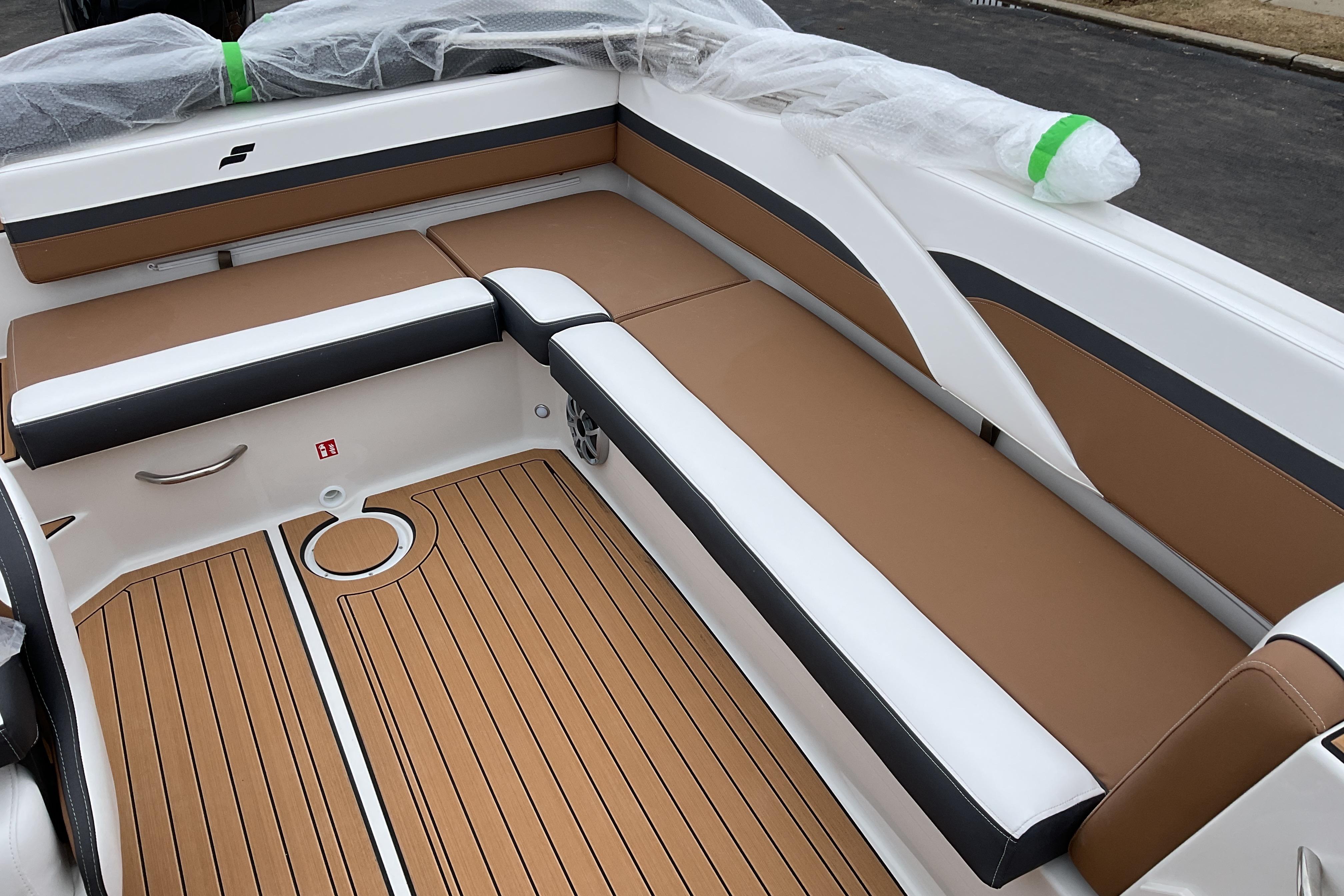 2026 Starcraft SVX 211 OB boat interior with tan and white seating, wood-style flooring.