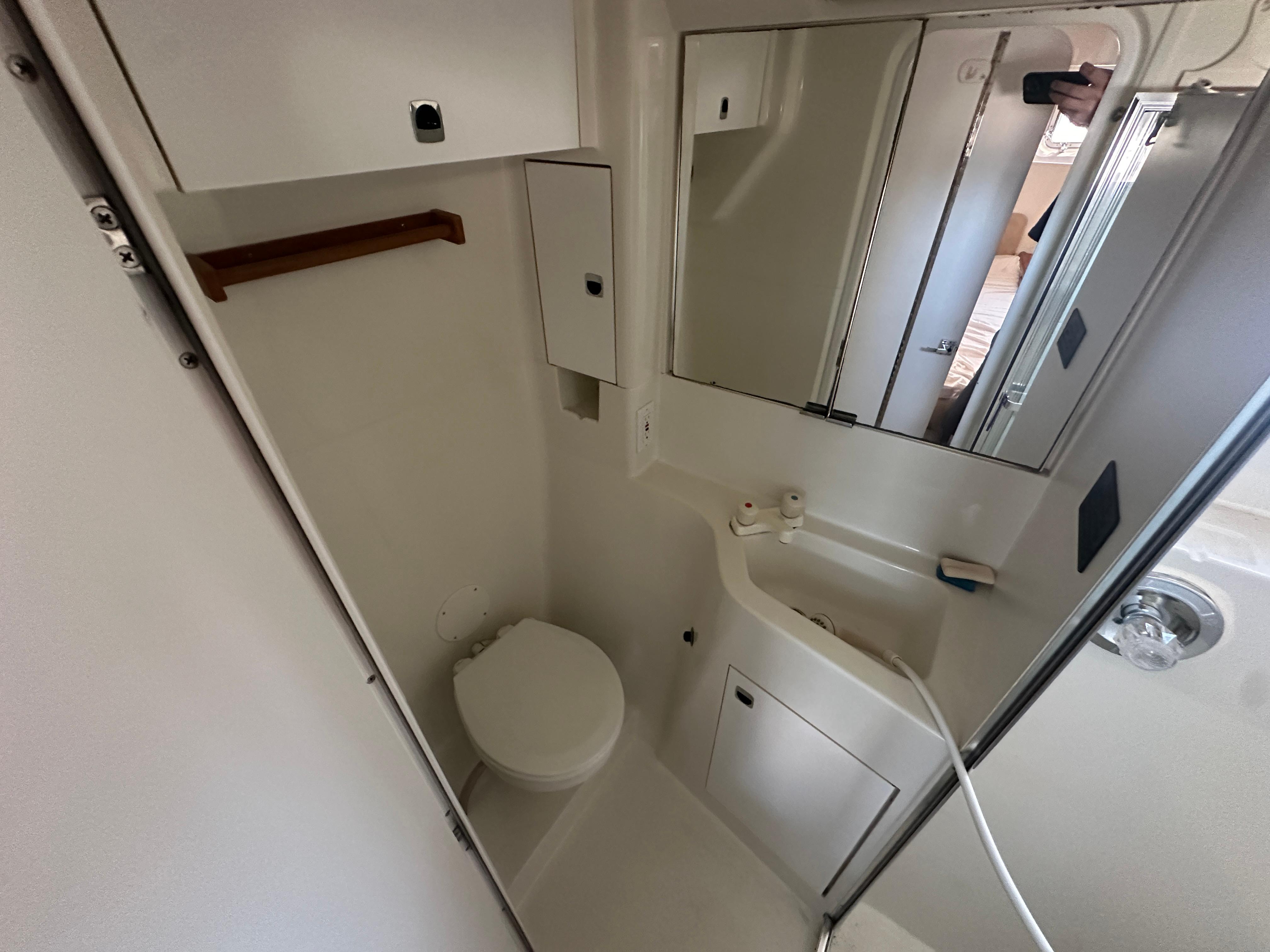 1994 Silverton 34 Aft Cabin Motor Yacht bathroom with toilet, sink, and mirror.