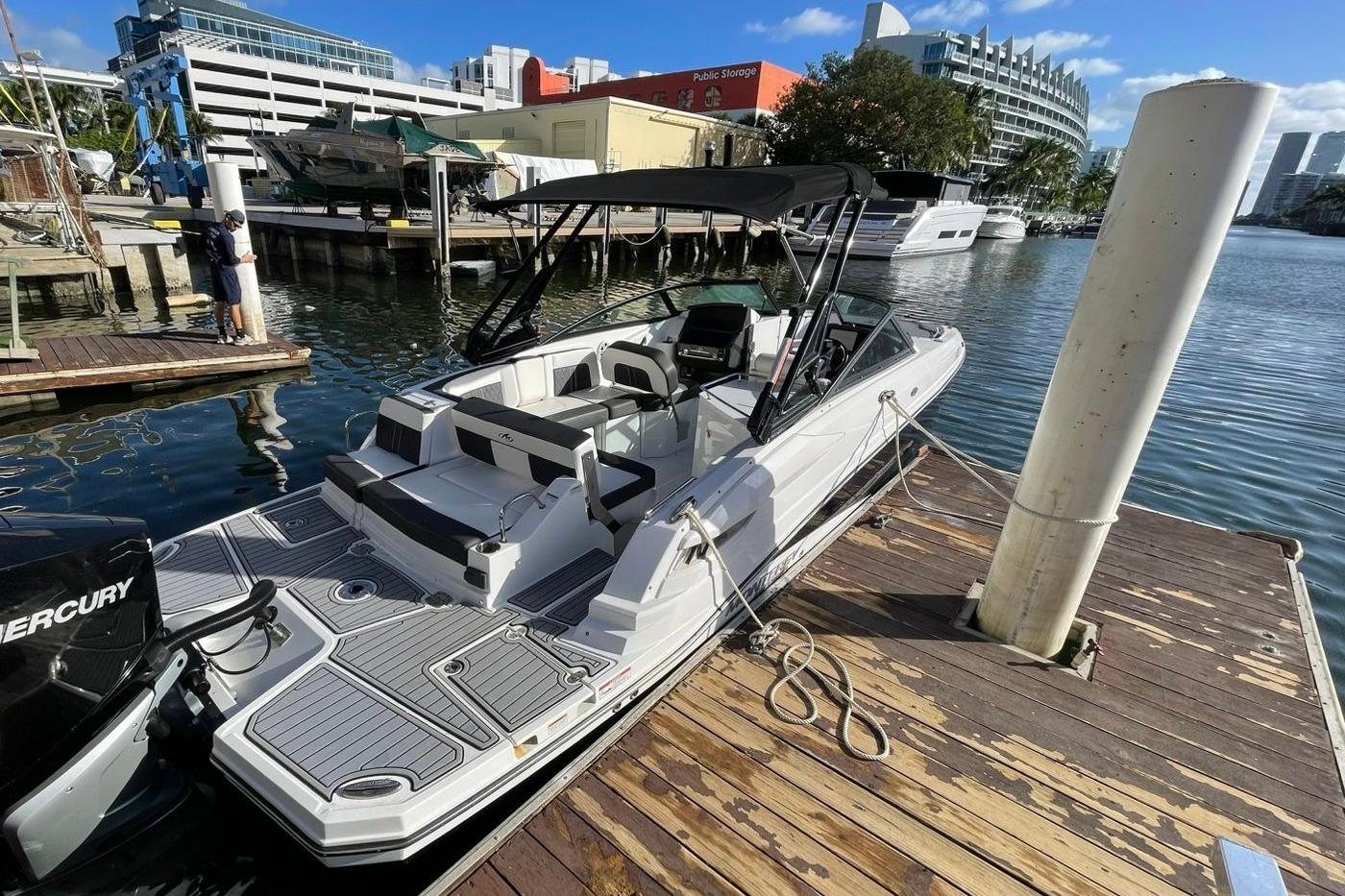2022 Monterey M-65 boat docked at marina, featuring sleek design and spacious seating.