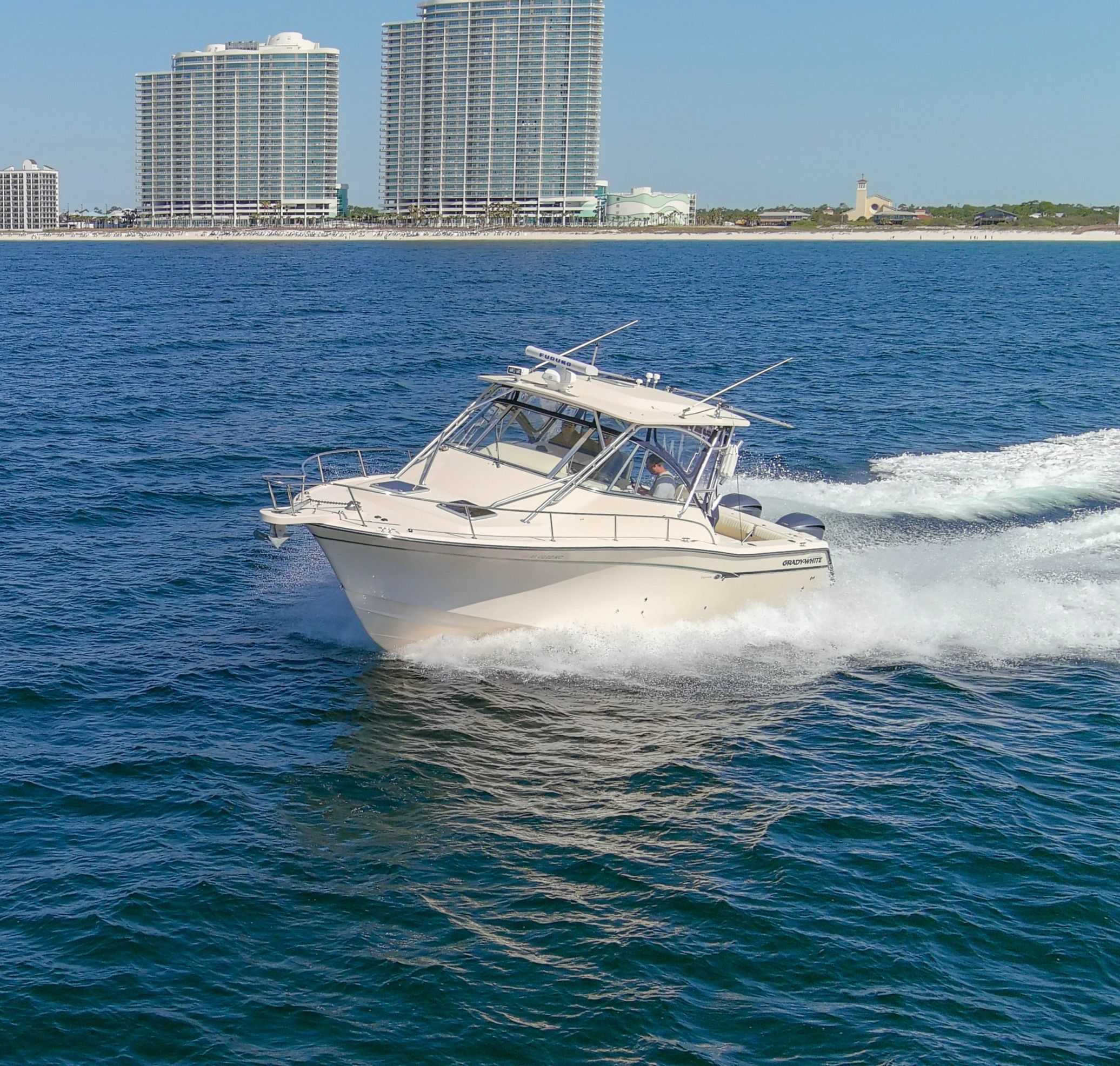 2009 Grady-White Express 330 boat on water near high-rise buildings.