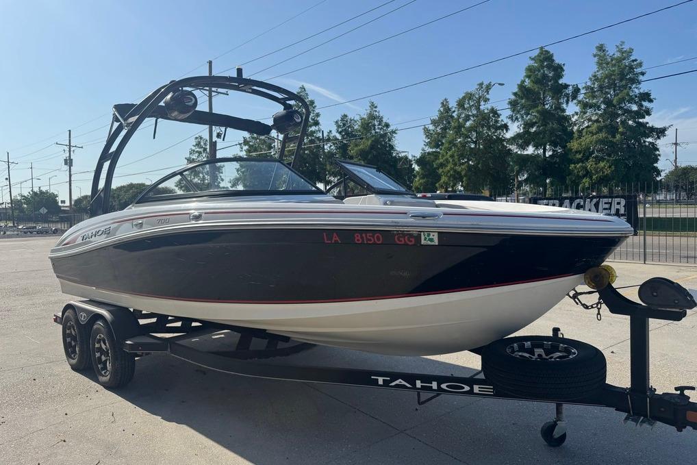 2018 Tahoe 700 TF boat on trailer, parked outdoors under clear sky.
