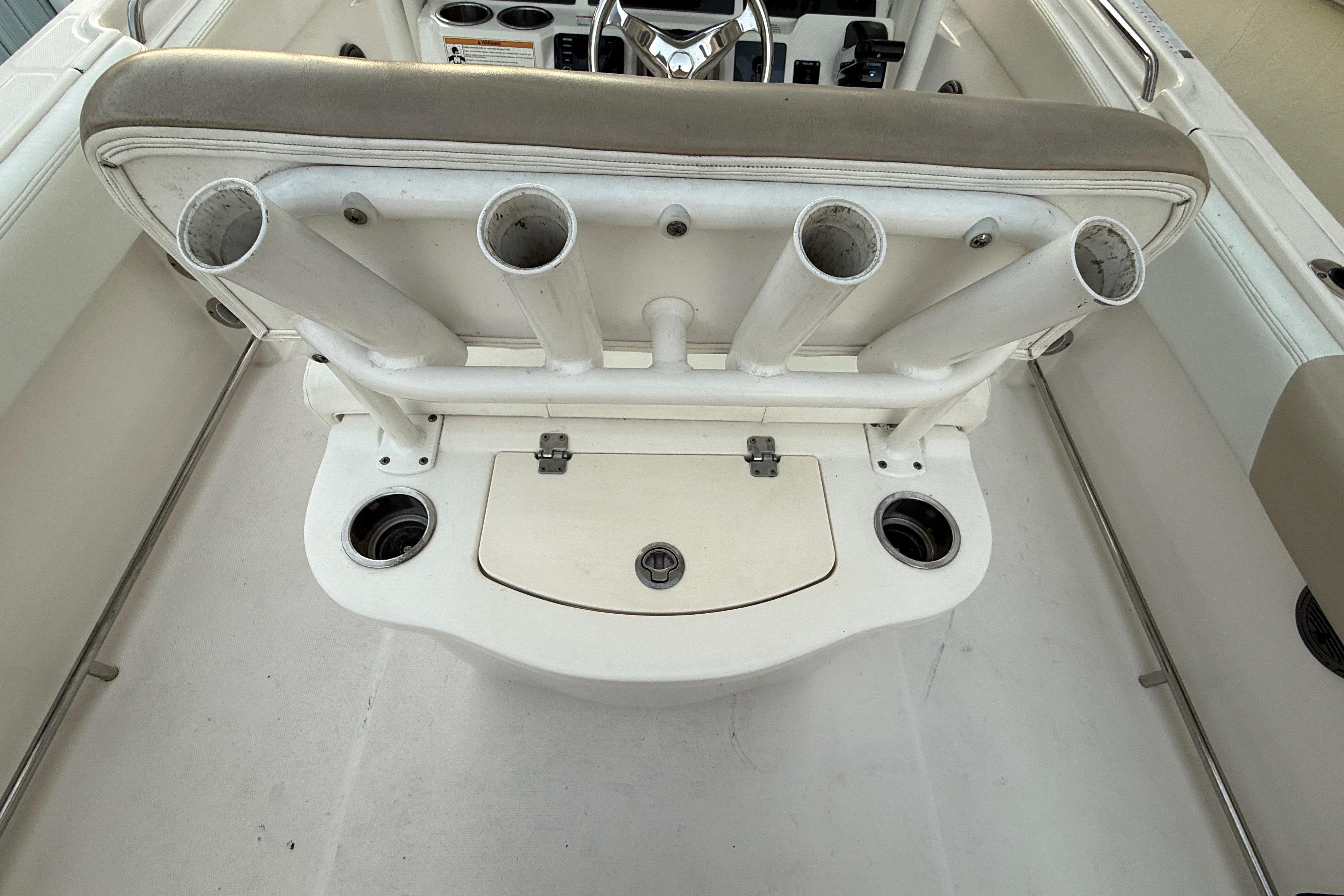 2018 Robalo R242 Center Console boat with rod holders and storage compartment.
