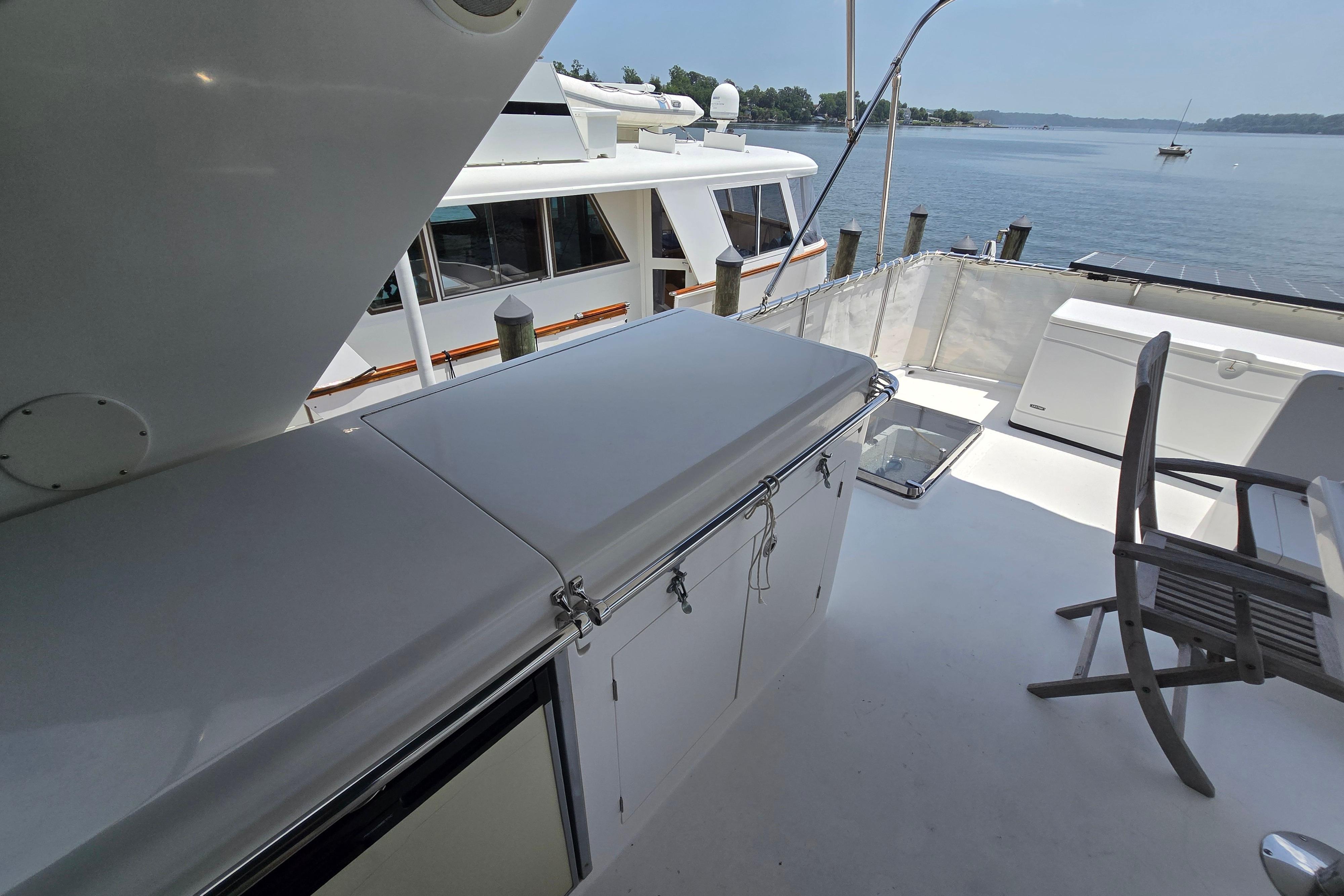 Deck view of 2004 Grand Harbour 58 yacht with seating and water backdrop.
